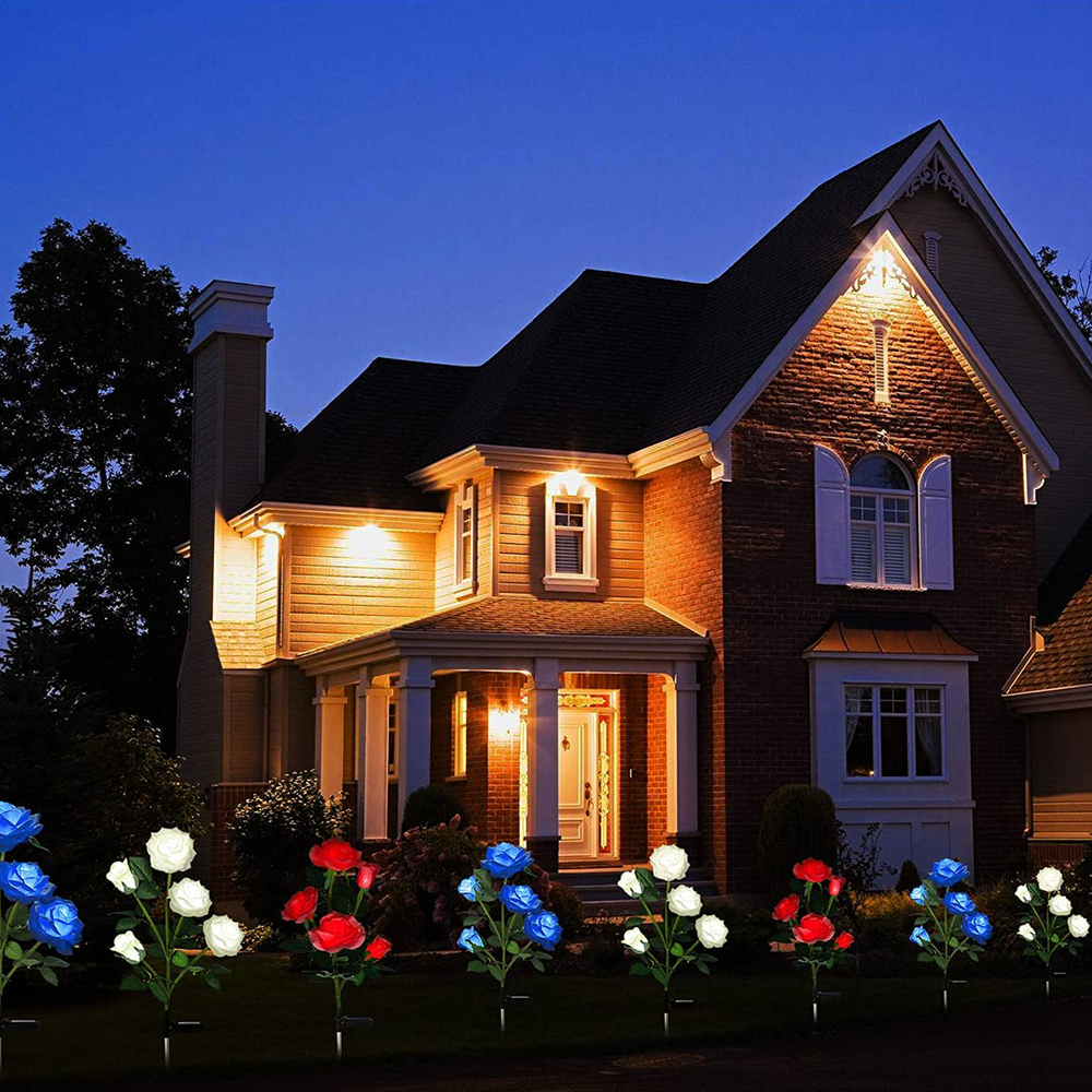 Nachtszenen mit einem Haus und solarbetriebenen Rosenlichtern im Vorgarten, beleuchtet.