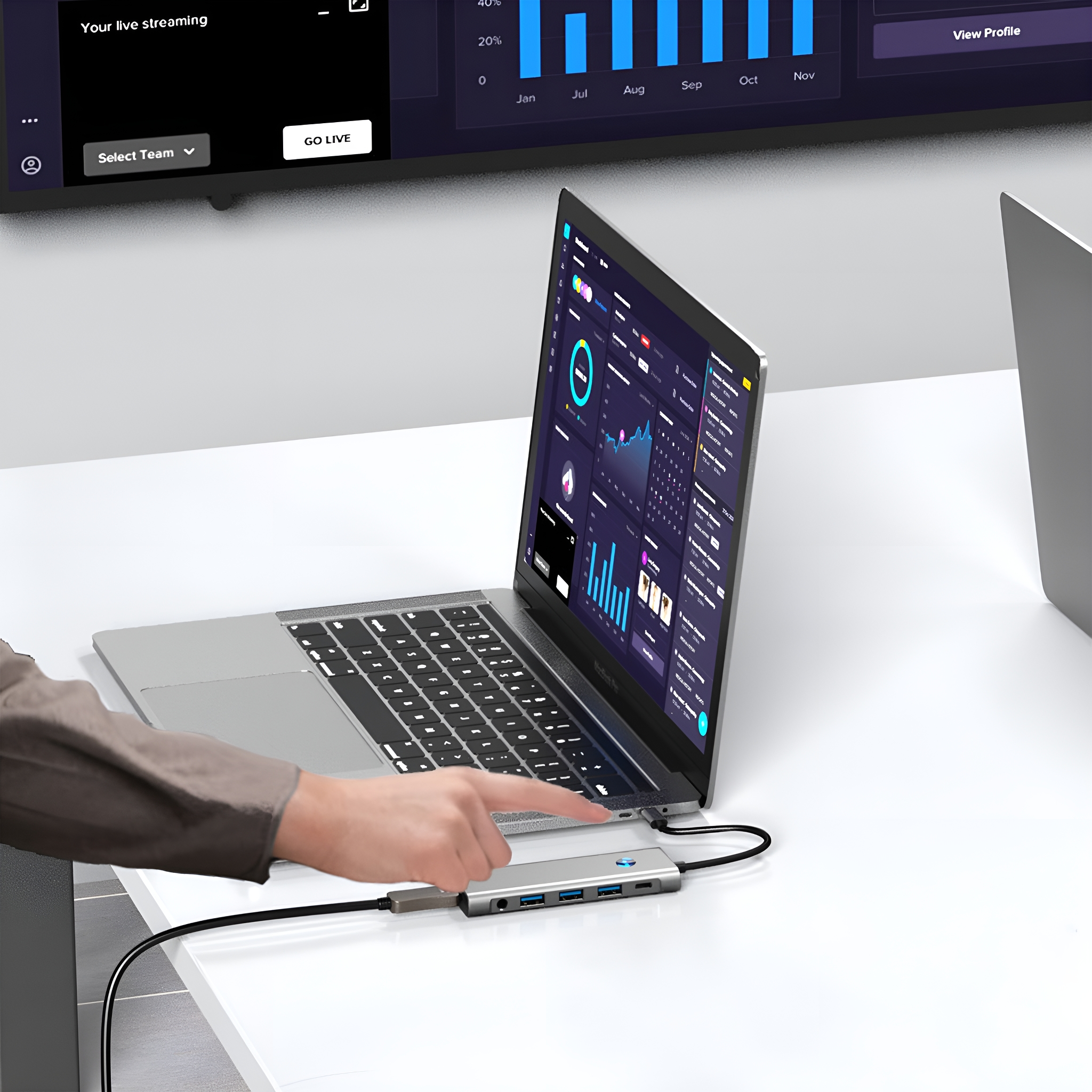 Ein Laptop, der mit einem Hub verbunden ist, mit einer Hand, die auf den Bildschirm zeigt.
