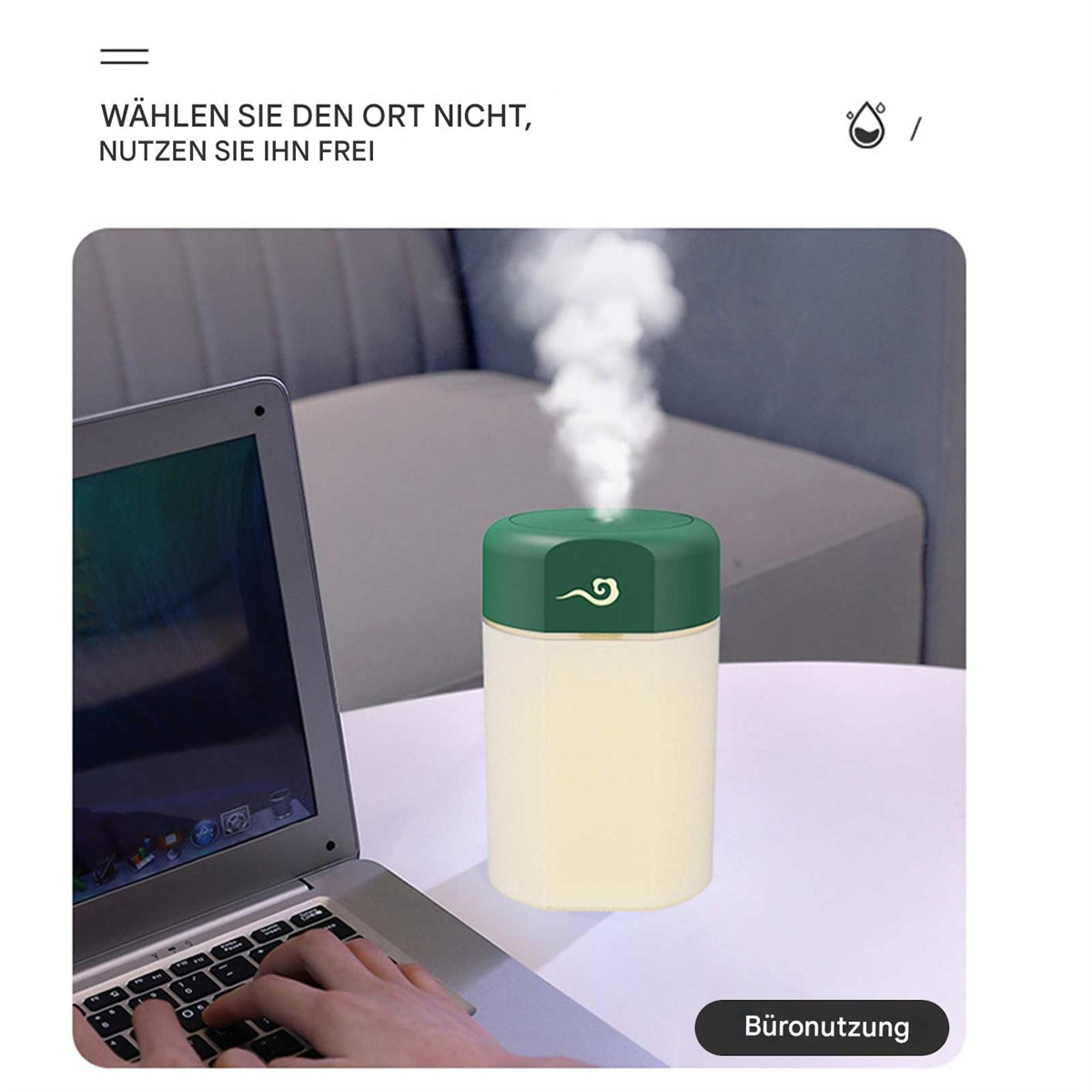 Ein weiß-grüner Luftbefeuchter erzeugt Dampf neben einem Laptop, Hand sichtbar.