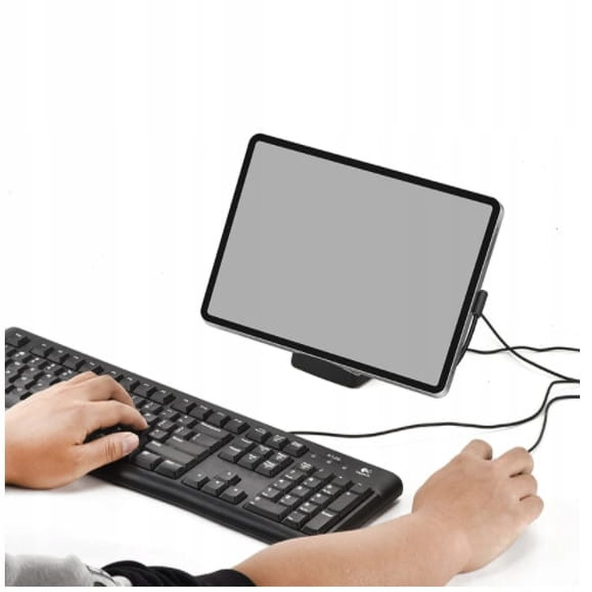 Tablet podparty stojakiem, podłączony do klawiatury i myszy. Tło jest białe.