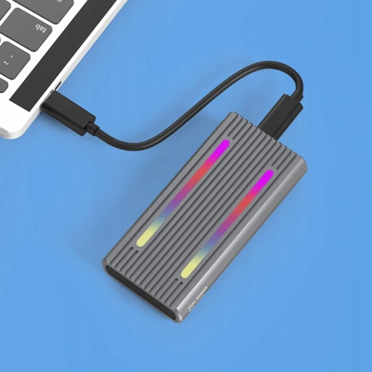 Szary dysk twardy podłączony do laptopa kablem USB. Niebieskie tło. Kolorowe światła na dysku.