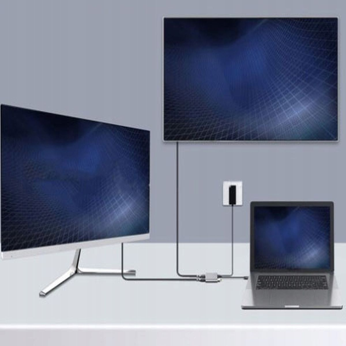 Dwa monitory i podłączony laptop. Jeden monitor jest u góry, wyświetlając siatkę. Szare urządzenie łączy je.