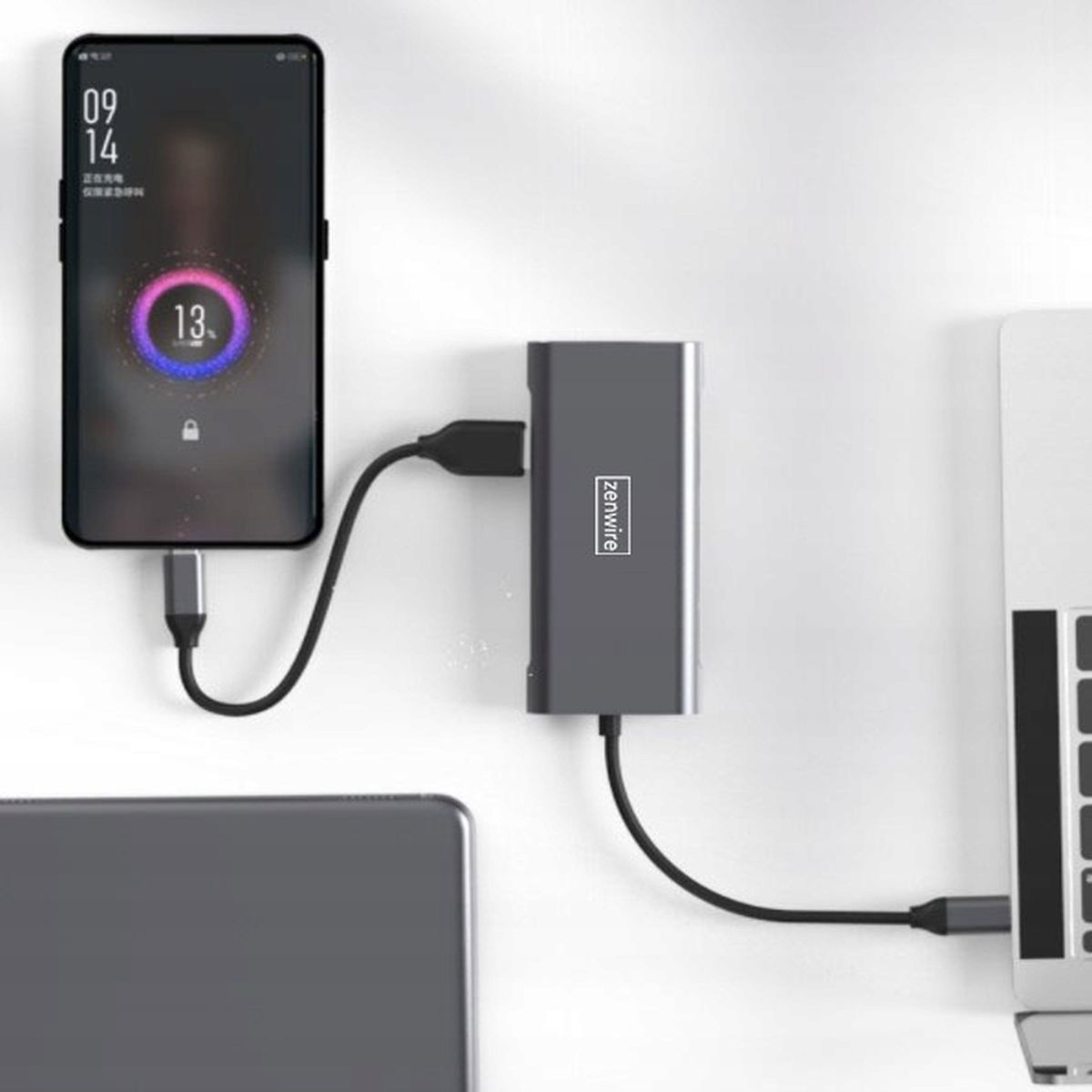Smartfon ładujący się przez szary hub podłączony do laptopa i ściany, tekst: zenwire.