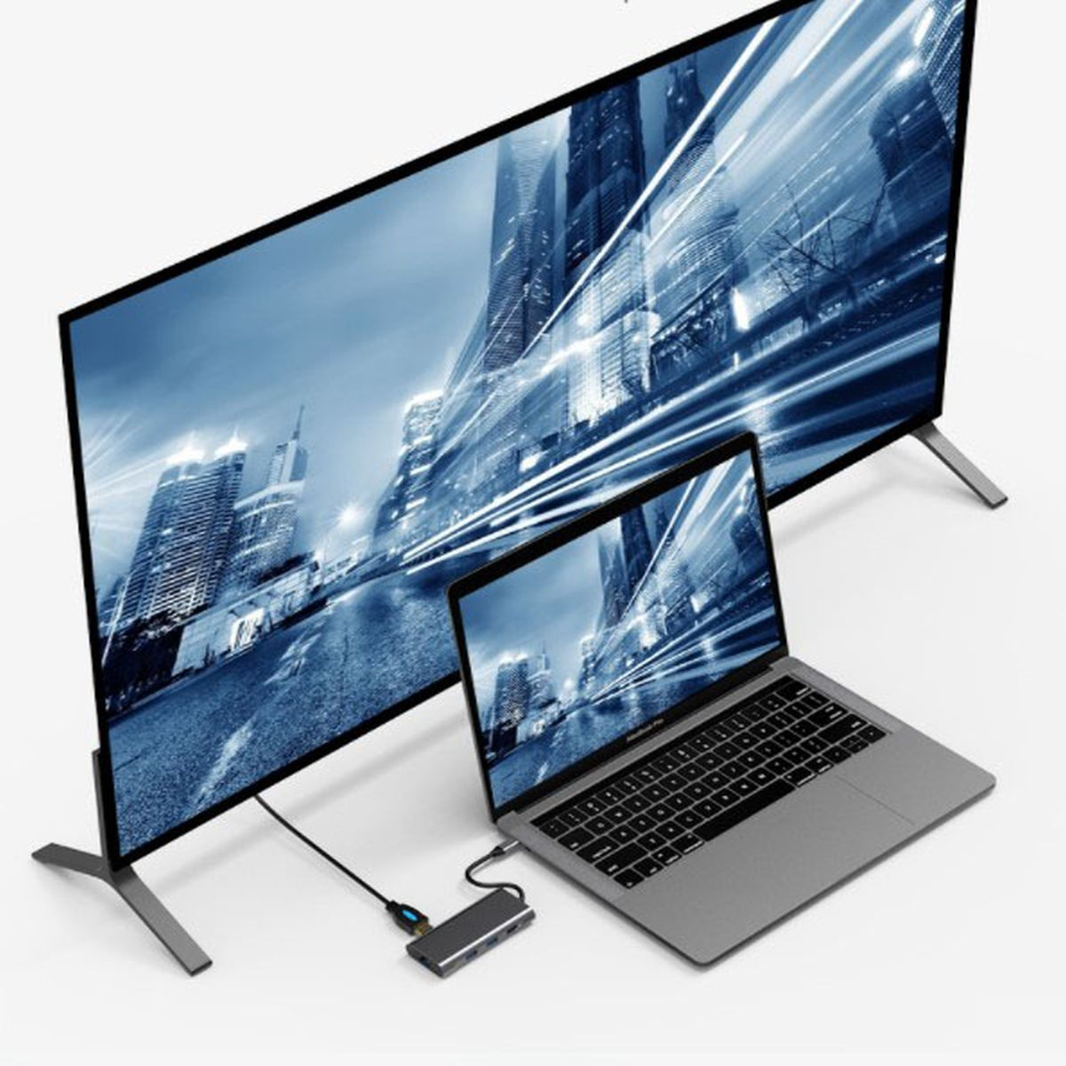 Laptop i telewizor pokazujące panoramę miasta. Połączone przez hub.