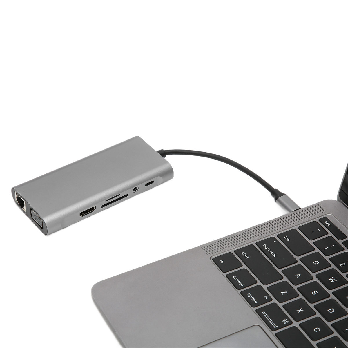 Silberner Hub, der mit einem Laptop verbunden ist, vor weißem Hintergrund.