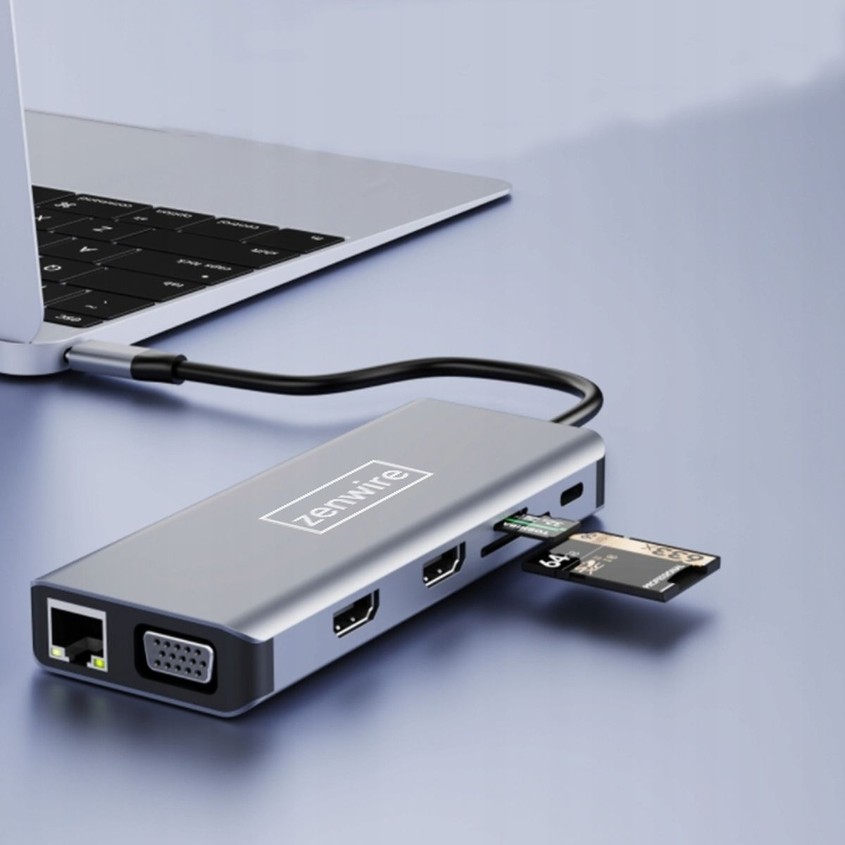 Srebrny hub USB-C z wieloma portami podłączony do laptopa i włożoną kartą SD.