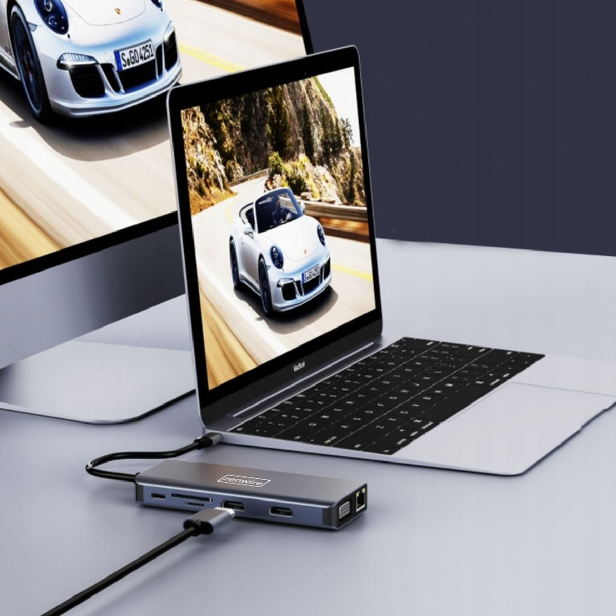 Laptop z obrazem samochodu na ekranie, z hubem USB na pierwszym planie.