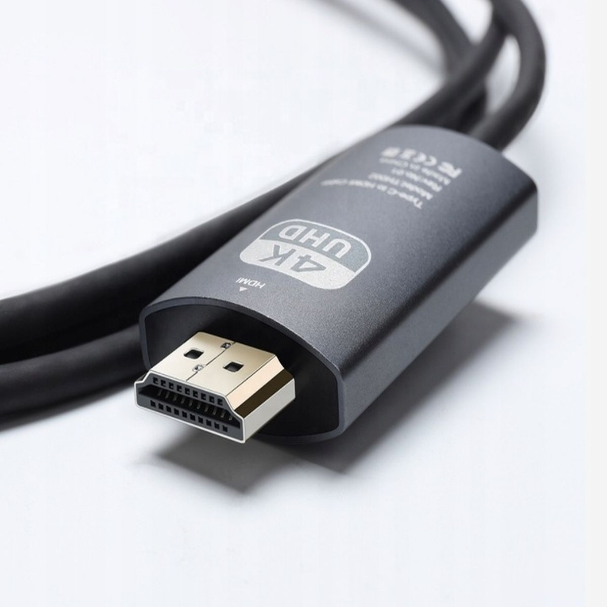 Czarny kabel HDMI z tekstem 4K UHD na złączu. Kabel znajduje się na białym tle.