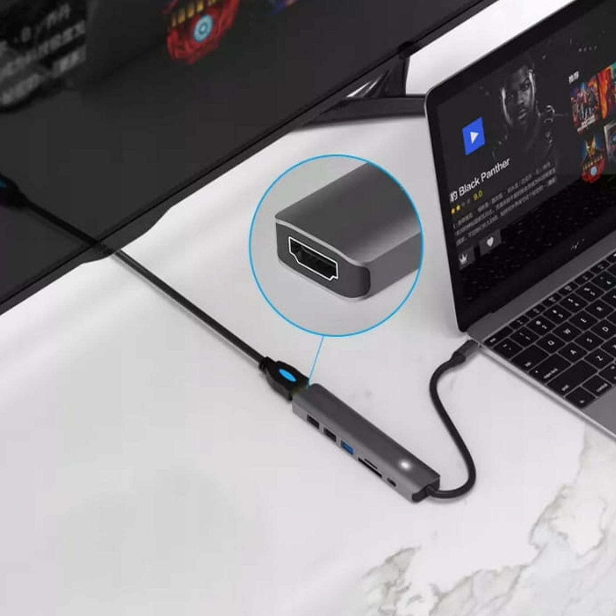 Szary hub USB-C podłączony do laptopa i monitora.