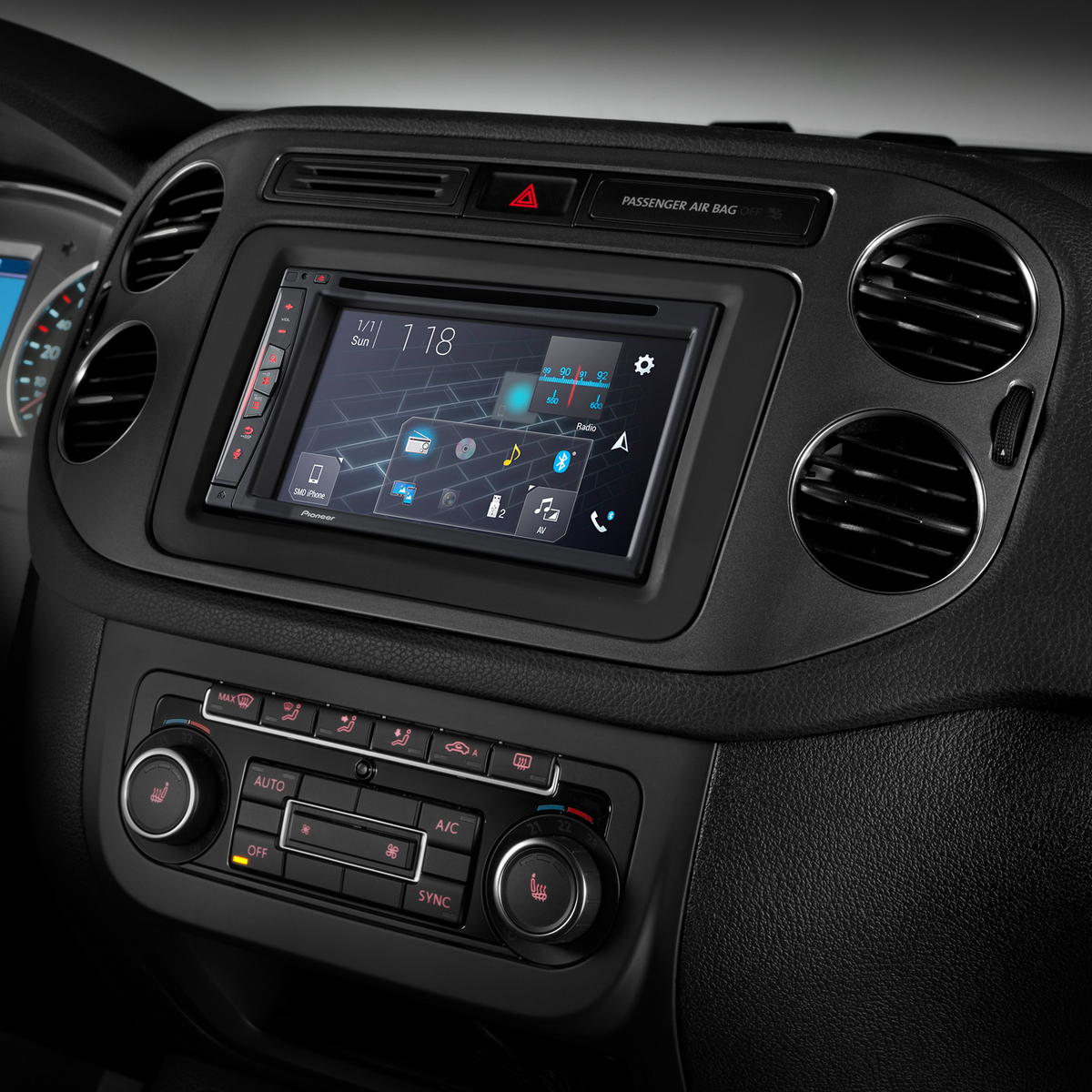 Armaturenbrett eines Autos mit einem Bildschirm, der Navigations- und Audiosteuerungen anzeigt. Klimaanlage und Radio darunter.