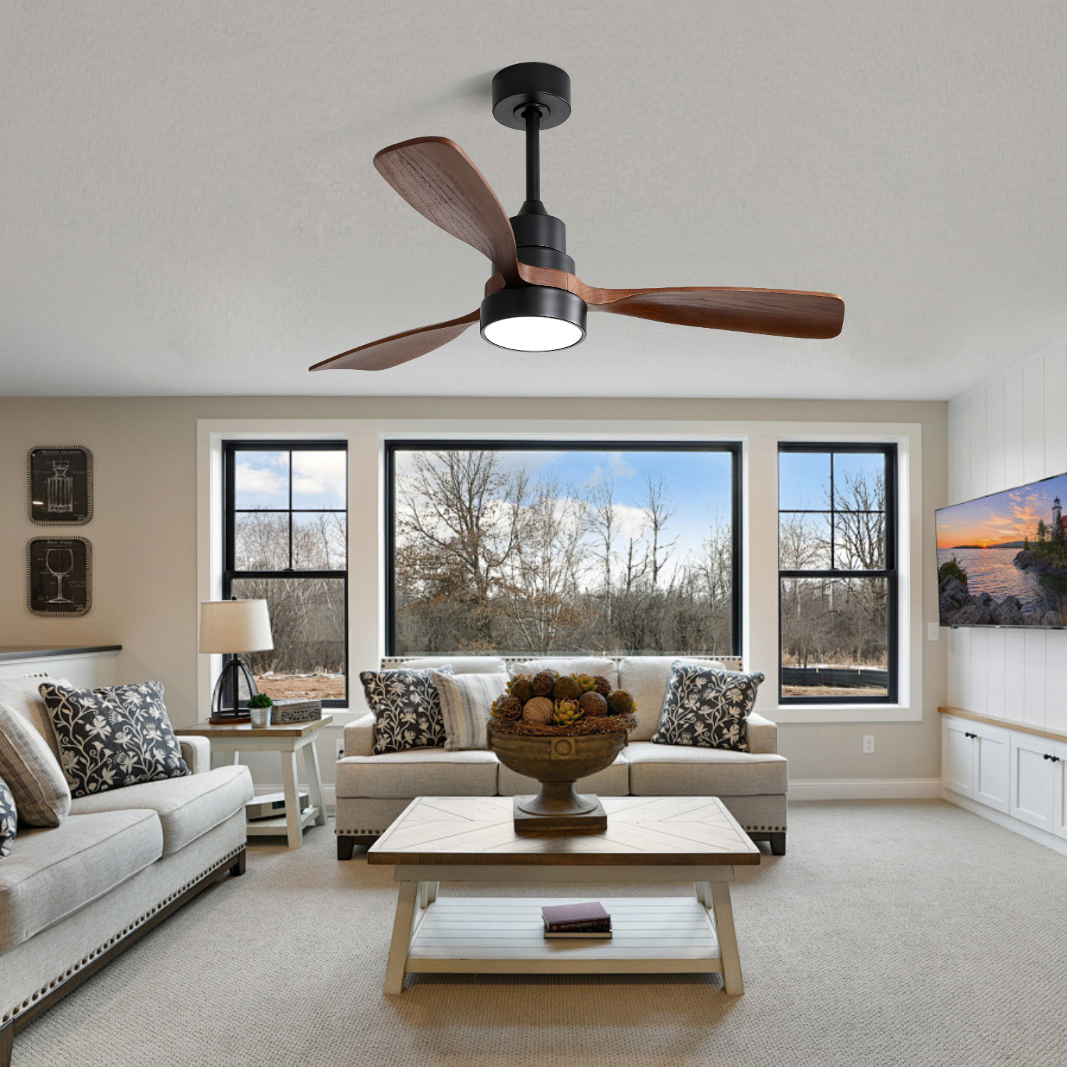 Ein Deckenventilator mit drei Holzblättern und einer Leuchte über einem Wohnzimmer mit Möbeln.
