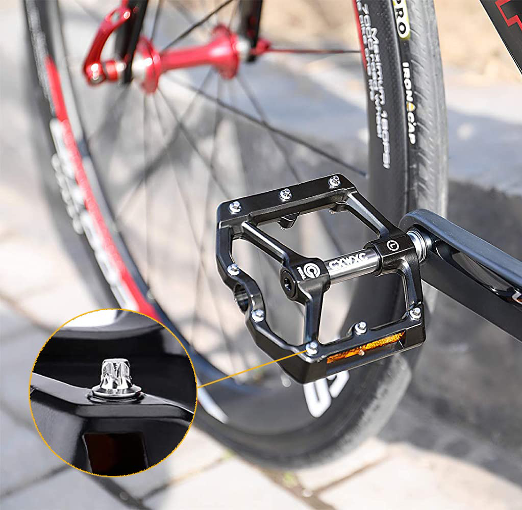 Nahaufnahme eines Fahrradpedals, Design des Pedals, Schraube im Fokus, Reifen im Hintergrund.