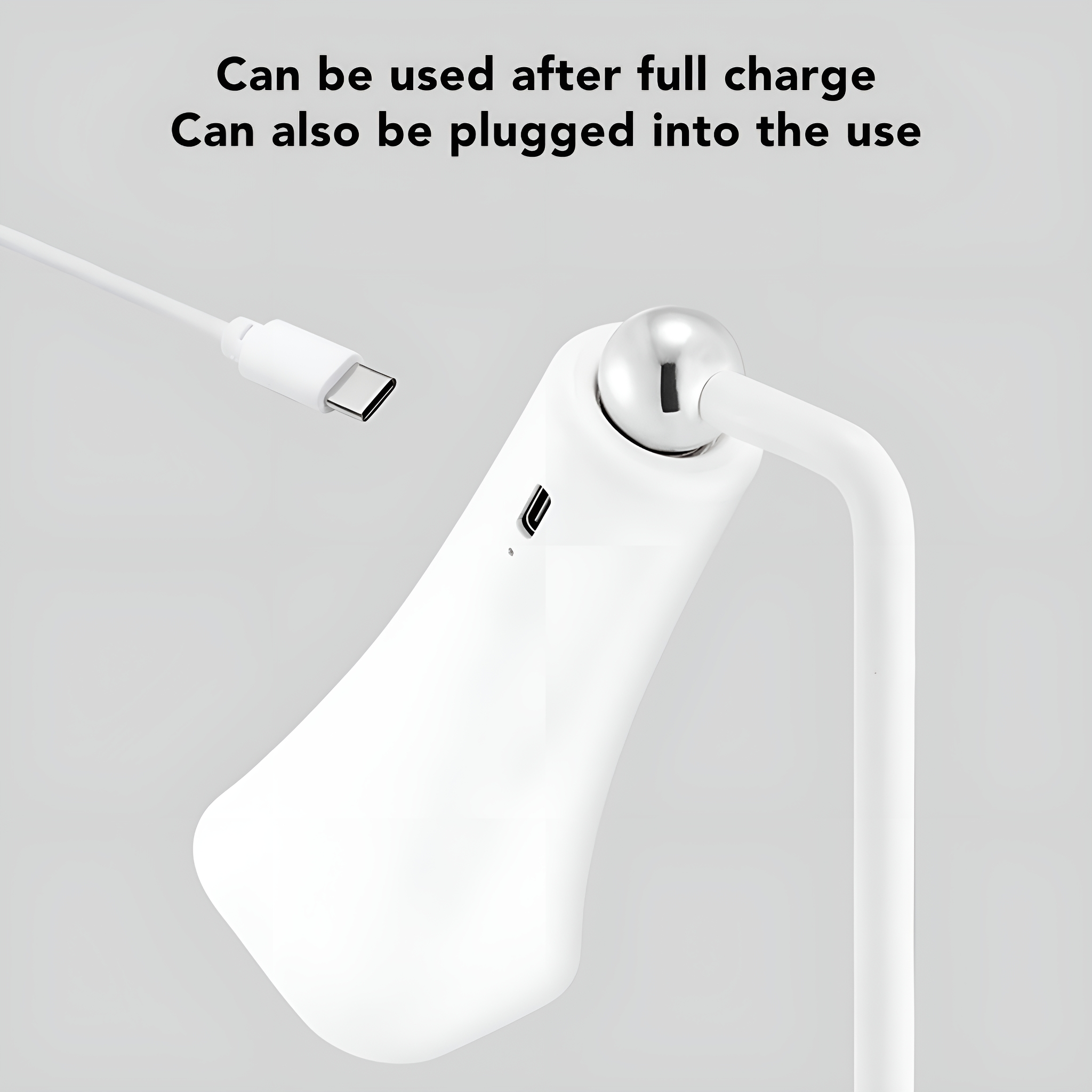 Eine weiße Lampe mit geschwungenem Design, verbunden mit einem USB-C-Kabel. Ein Ladeanschluss ist sichtbar.