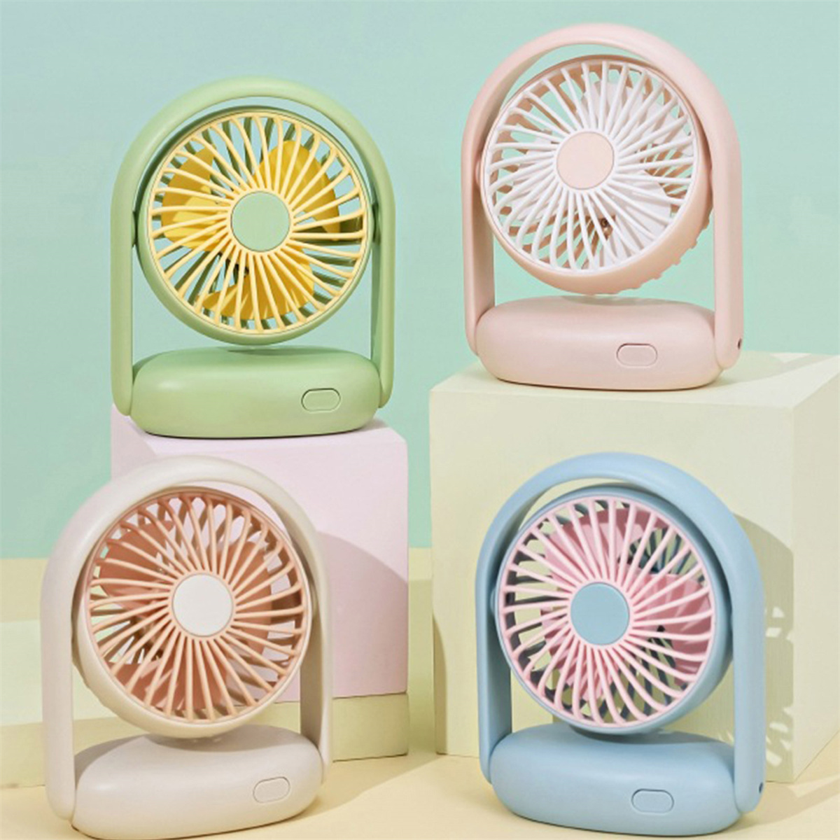 Vier kleine Ventilatoren in verschiedenen Farben: Grün, Rosa, Beige und Blau. Jeder mit Griff.