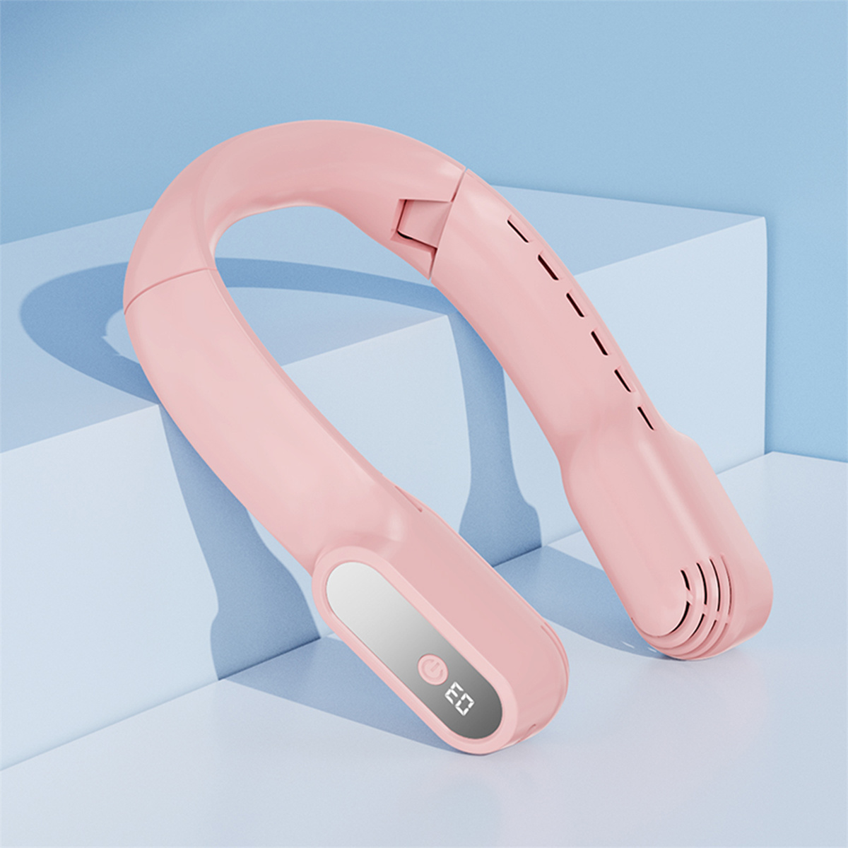 Rosa Nackenventilator, geschwungenes Design, mit kleinem Display, das '03' anzeigt, auf blauer und weißer Oberfläche platziert.