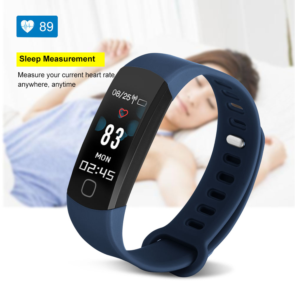 Eine blaue Smartwatch zeigt Herzfrequenz und Zeit, im Hintergrund schläft eine Person.