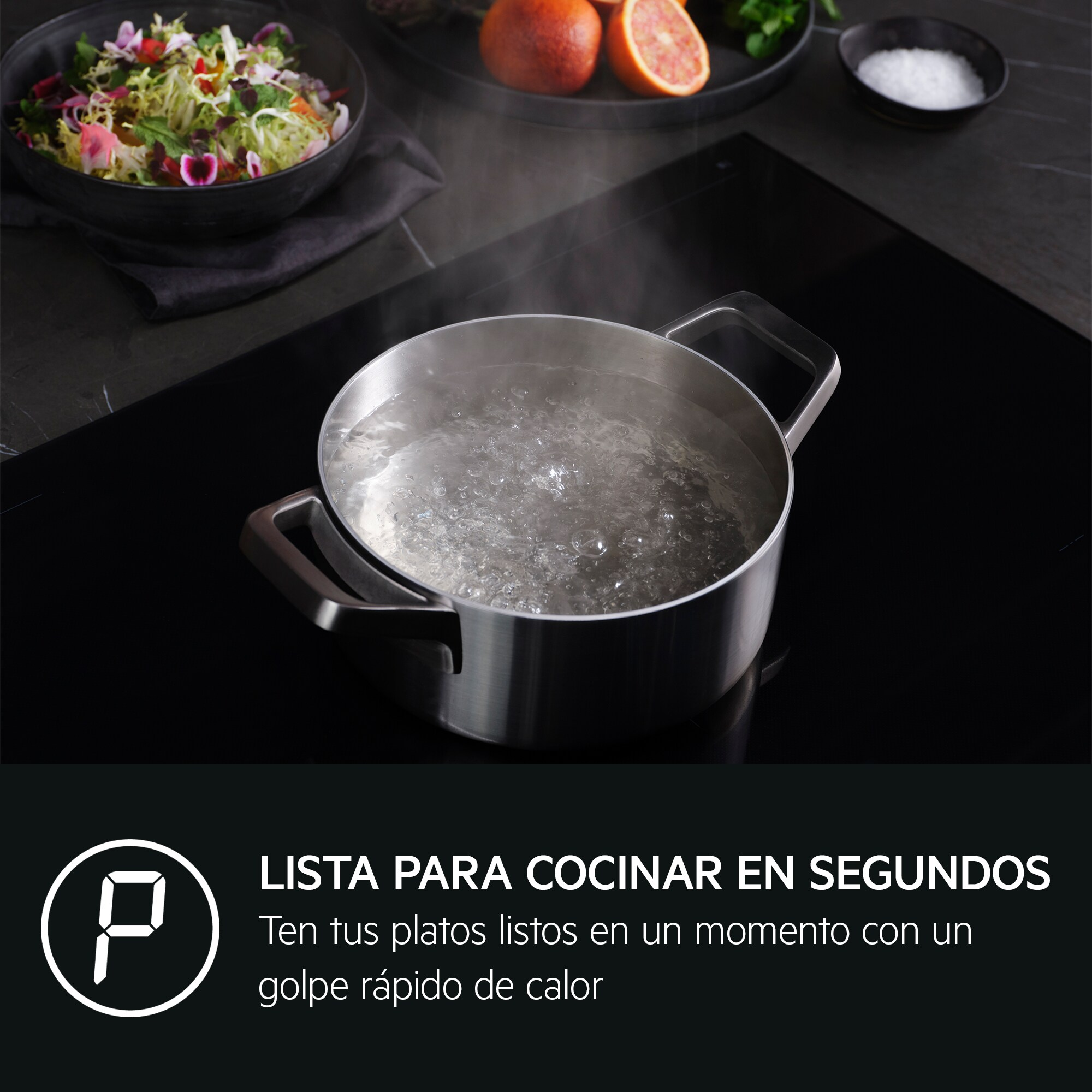 Una pentola di acqua bollente su un piano cottura nero. Altri alimenti sullo sfondo.