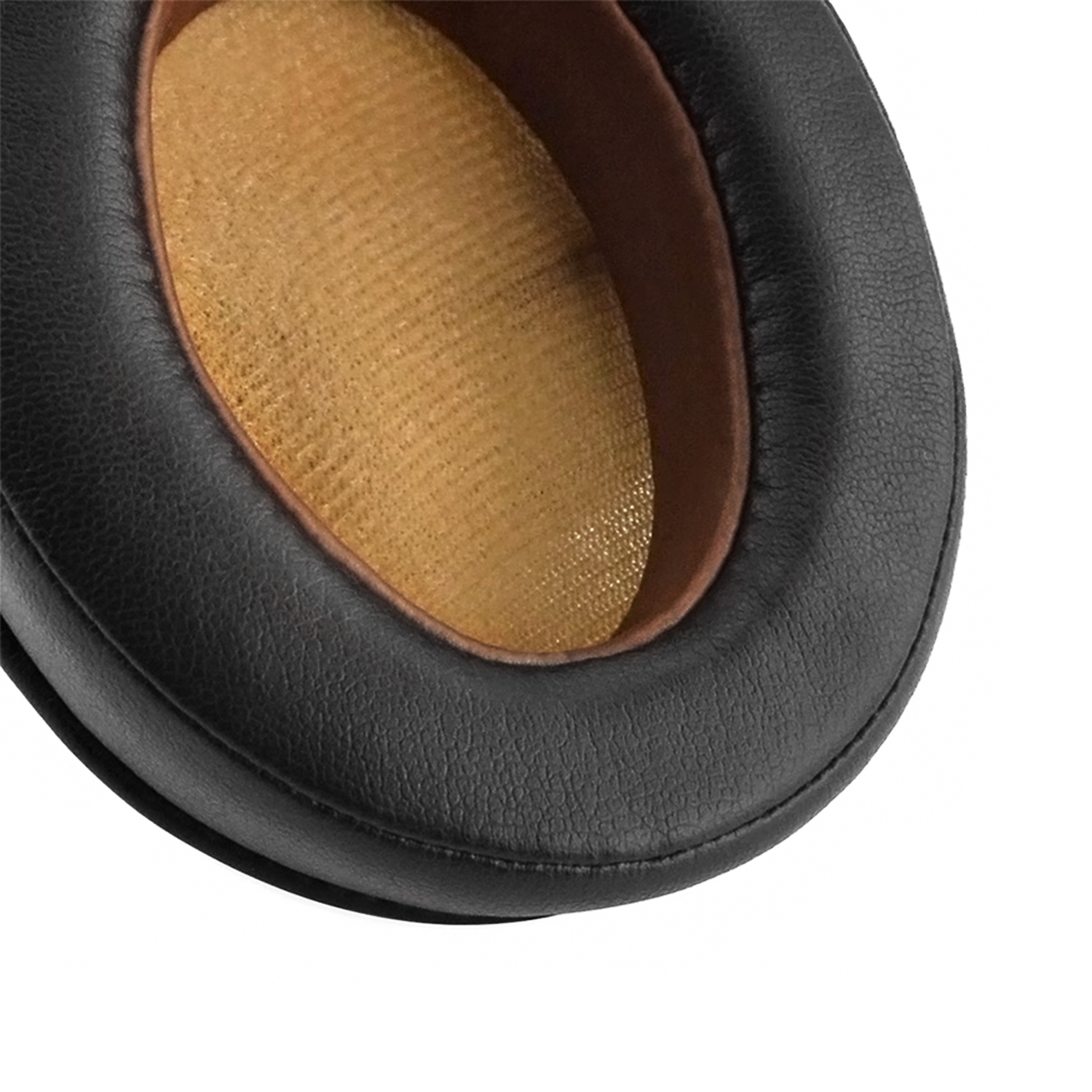 Zbliżenie czarnej poduszki nausznej słuchawek, ze złotym wnętrzem z siatki. Czarny materiał skóropodobny.