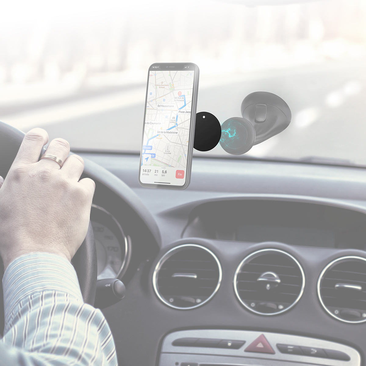 Un telefono con app mappa è montato sul cruscotto di un'auto. Mano sul volante.