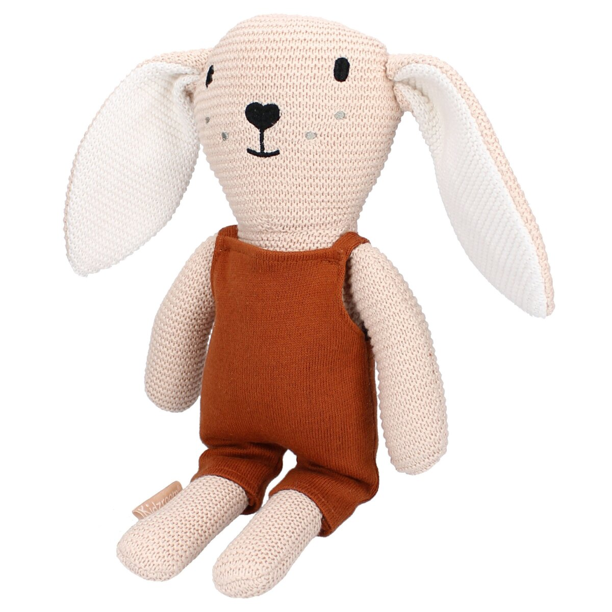 Beiges, gestricktes Hasenspielzeug mit orangefarbenem Overall. Es sitzt auf weißem Untergrund.