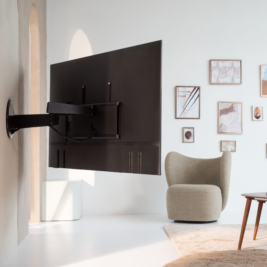 Telewizor zamontowany na ścianie, z nowoczesnym układem salonu, w tym krzesło i dekoracje.