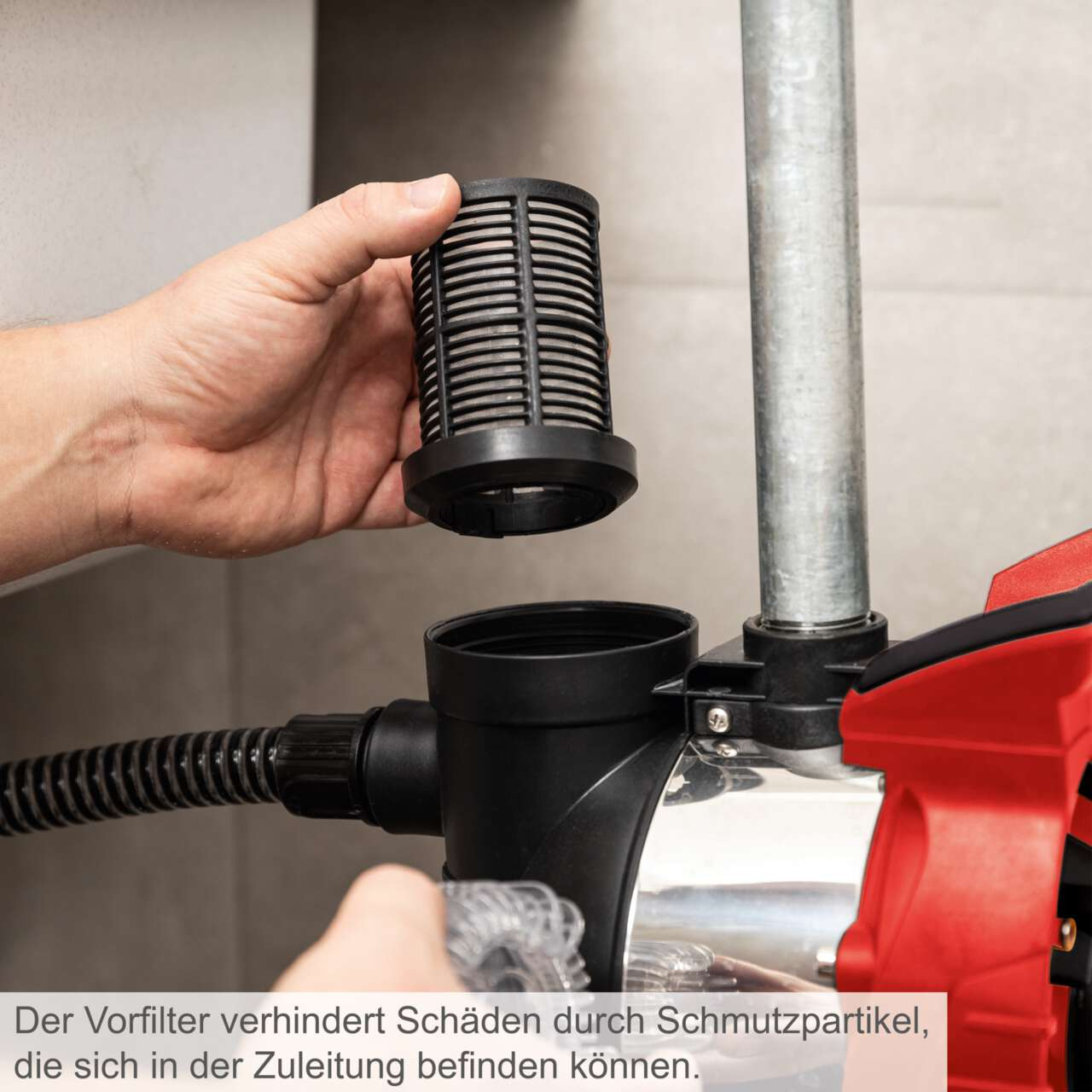 Eine Hand entfernt einen schwarzen Filter von einer Wasserpumpe, mit Text auf Deutsch.