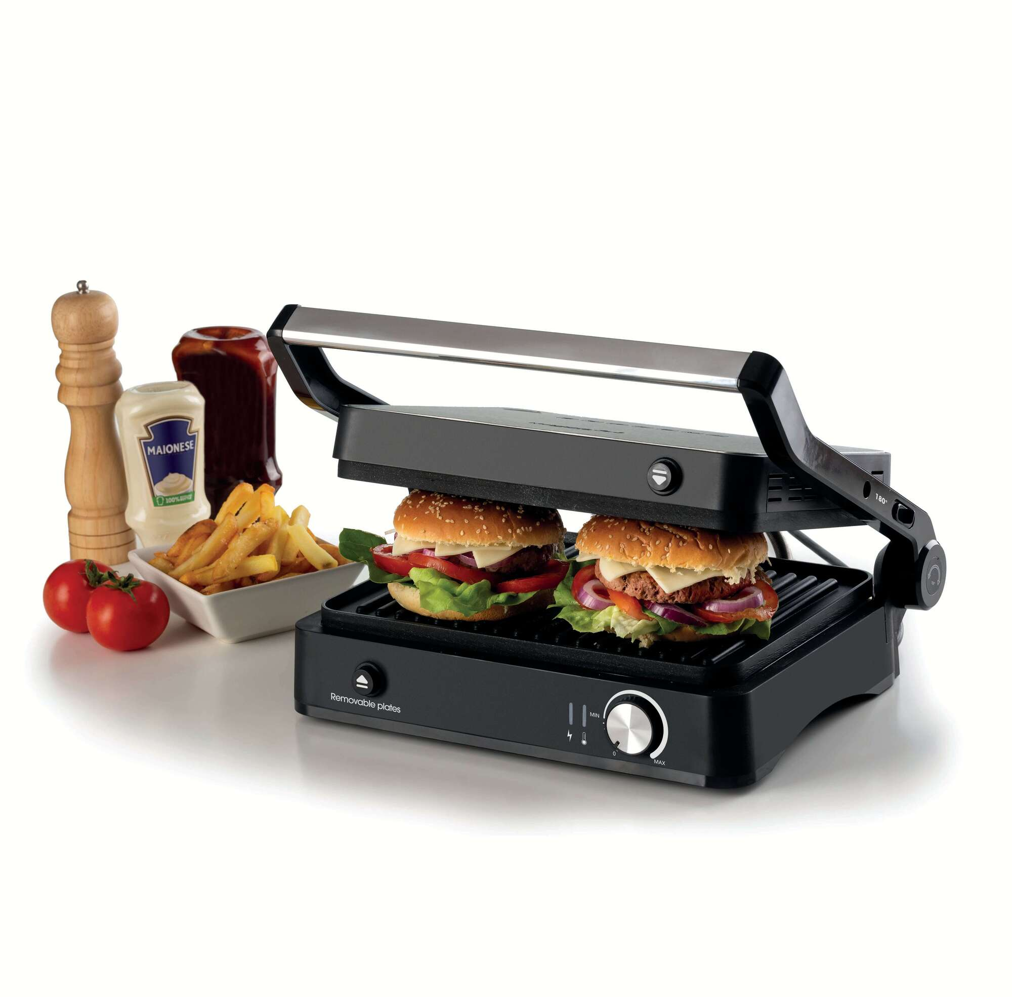 Schwarze Panini-Presse mit zwei Burgern, daneben Pommes, Tomaten und Gewürze.