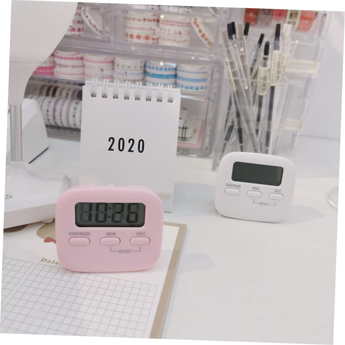 Ein rosa digitaler Timer und ein 2020 Kalender auf einem Schreibtisch.