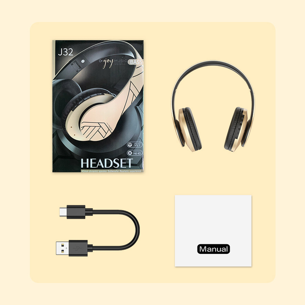 Kopfhörer, Box, Ladekabel und Handbuch auf hellgelber Oberfläche.