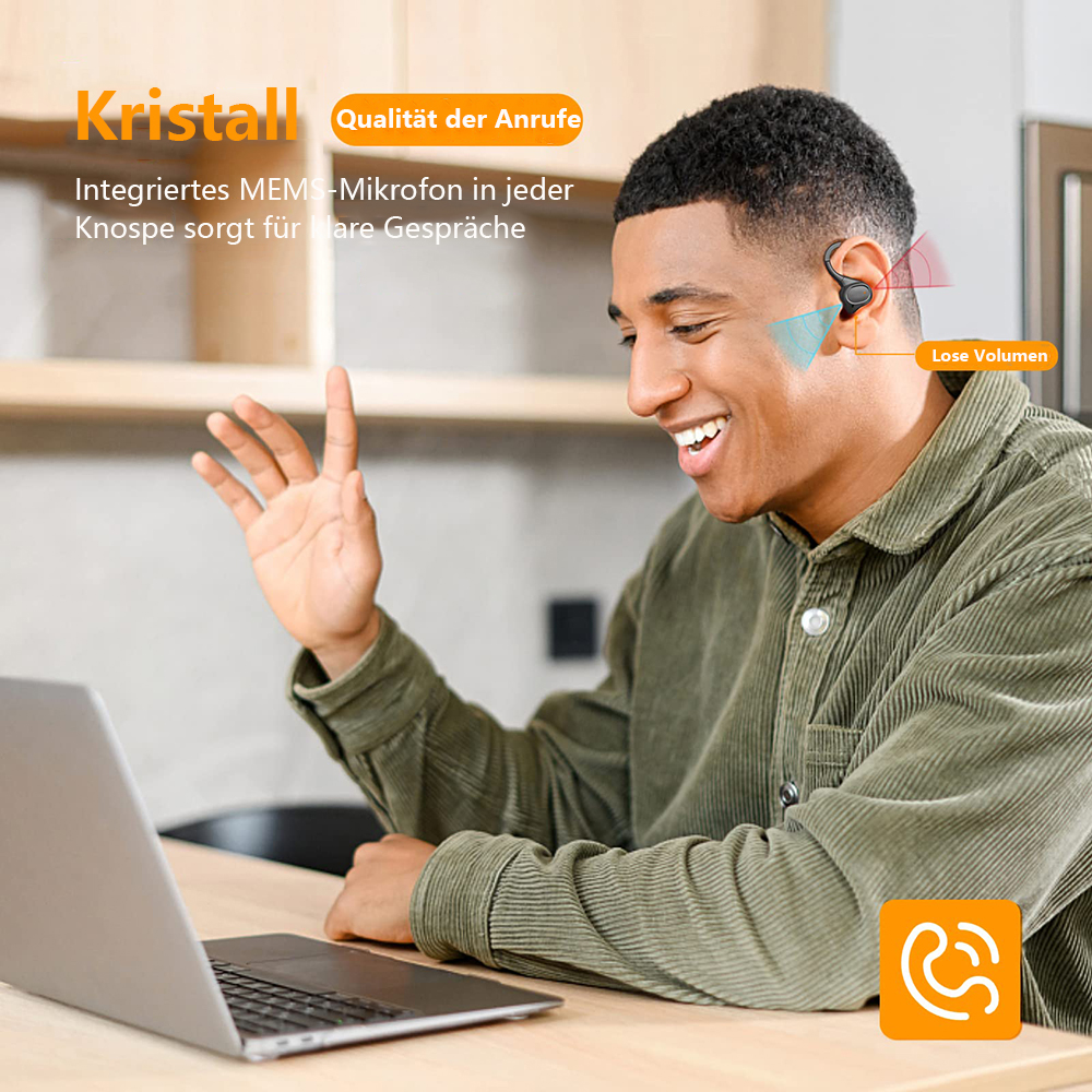 Ein Mann lächelt, während er ein Headset trägt. Ein Laptop liegt auf dem Tisch.