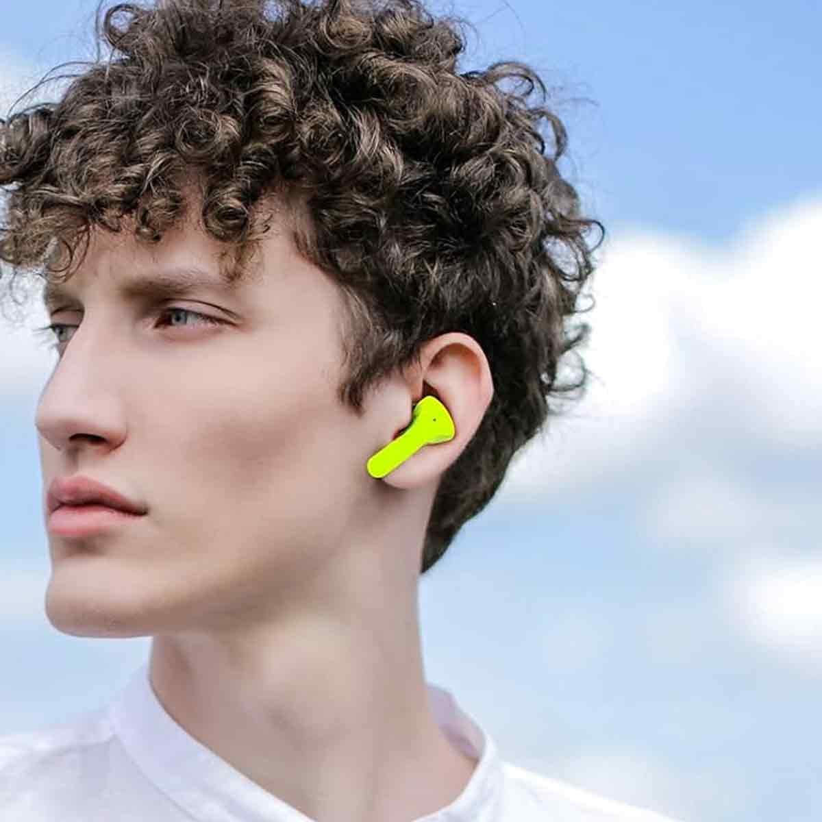 Ein Mann mit einem Ohrhörer im Ohr. Der Ohrhörer ist gelb.