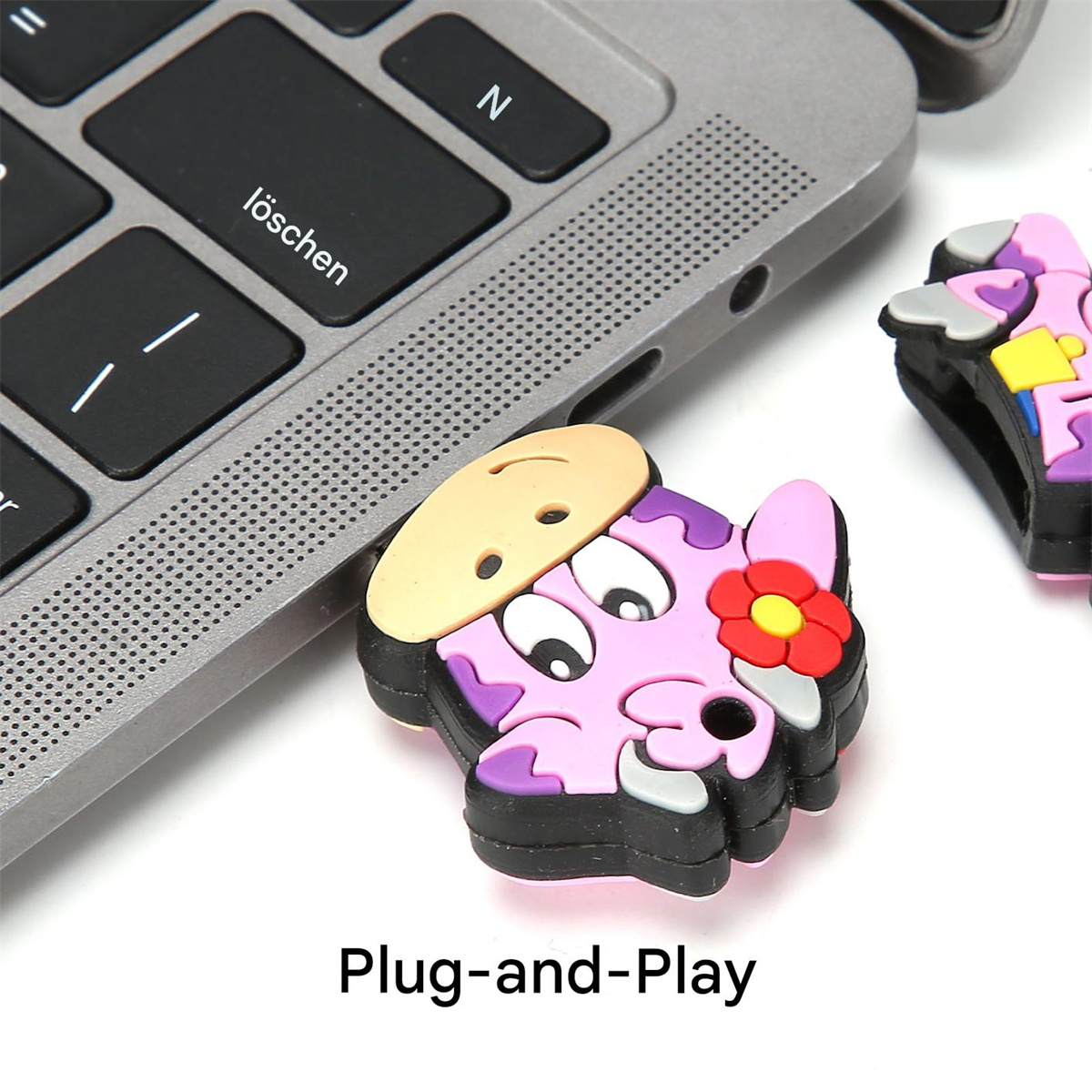Ein kuhförmiger USB-Stick neben einer Laptop-Tastatur, darunter der Text Plug-and-Play.
