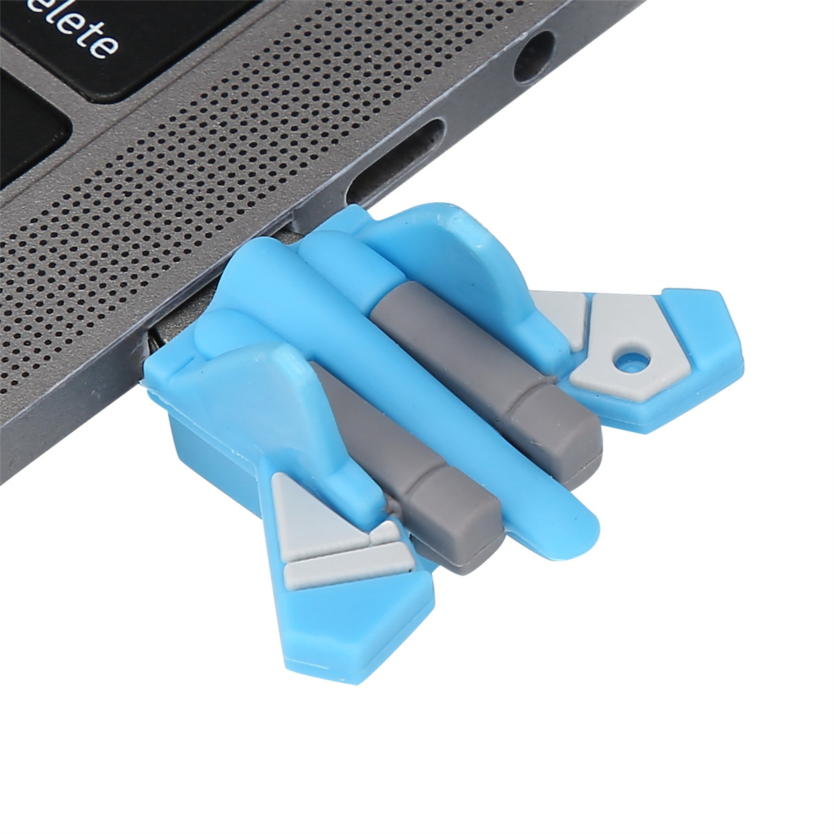Blauer USB-Stick in Form eines Kampfflugzeugs, der in einen Laptop gesteckt wird.