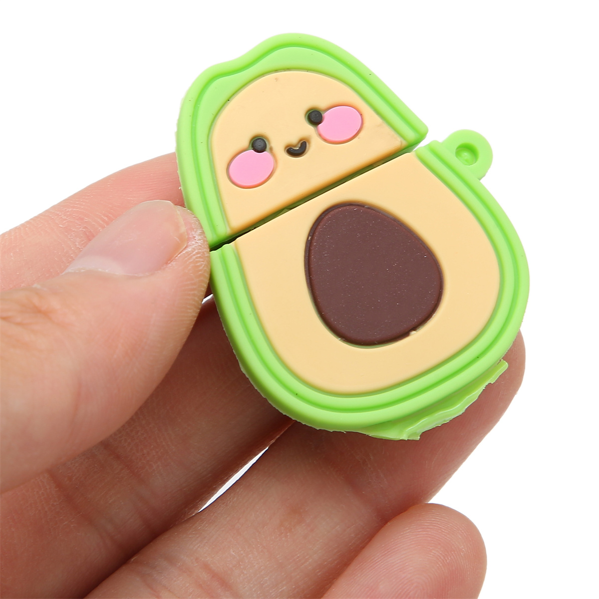 Eine avocadoförmige Hülle, grün mit einem lächelnden Gesicht, wird von einer Hand offen gehalten. Die Innenseite ist beige.