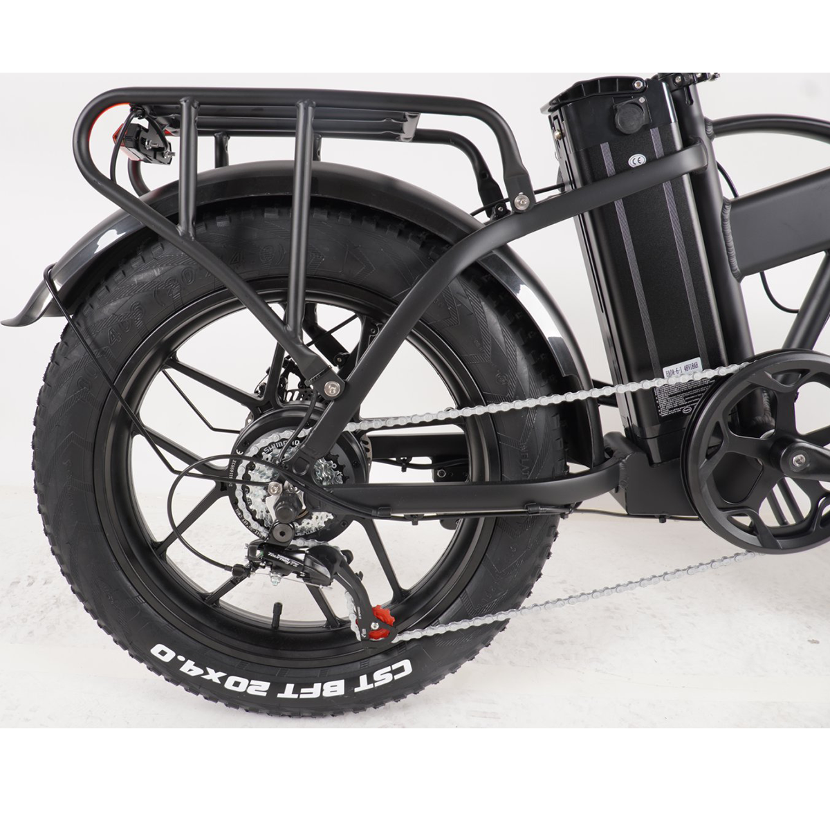 Czarny elektryczny rower z grubymi oponami, tylne koło w centrum uwagi.