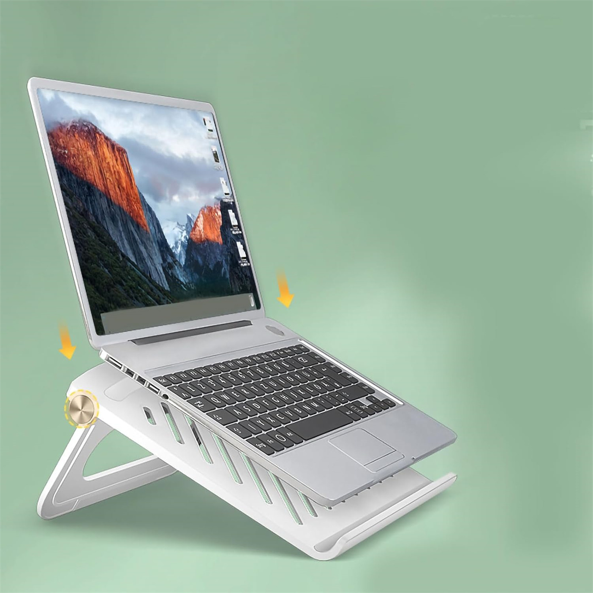 Ein Laptop auf einem weißen Ständer. Der Bildschirm zeigt eine Berglandschaft. Grüner Hintergrund.