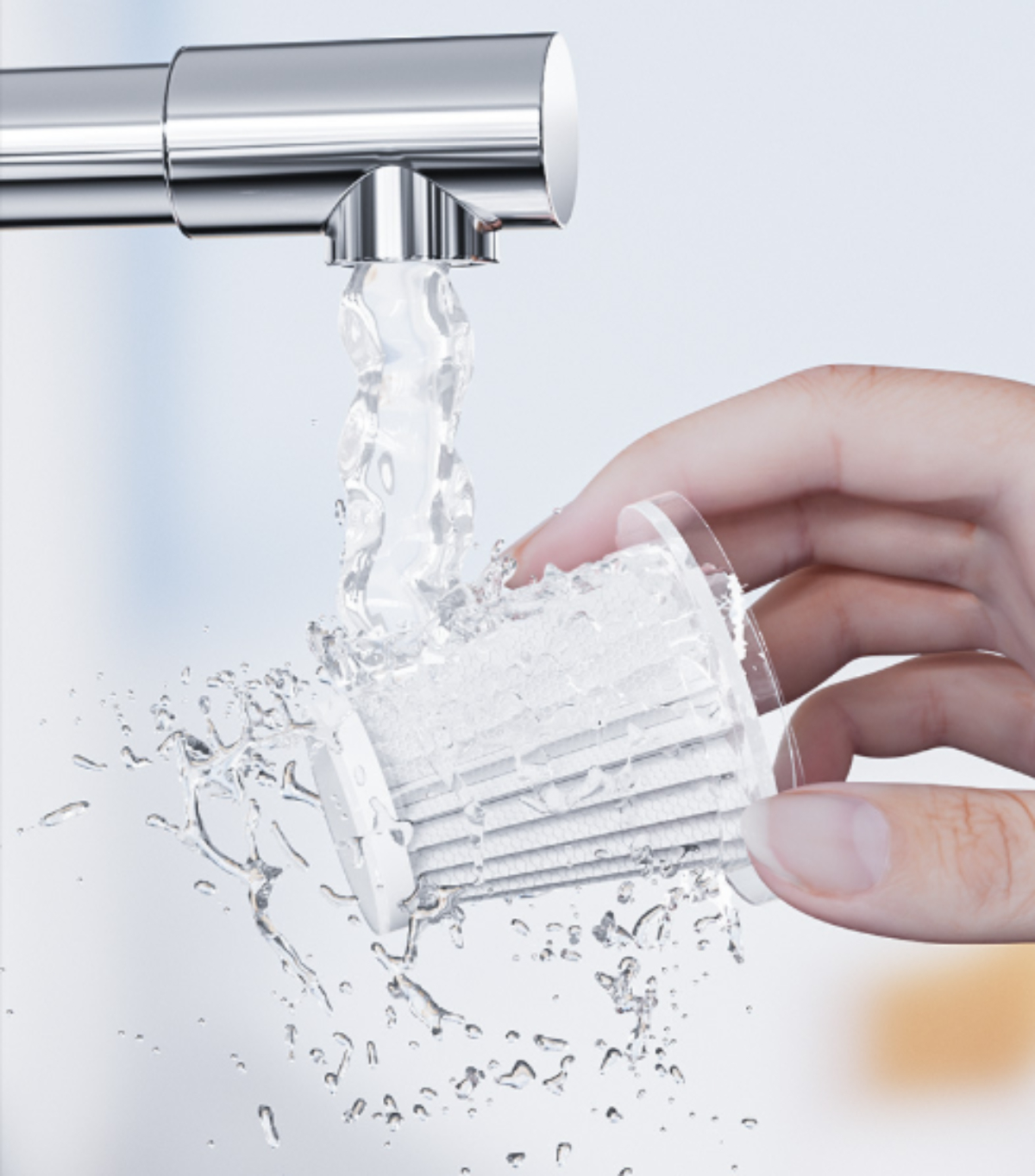 Eine Hand hält einen Filter unter fließendem Wasser, mit Wasserspritzern.