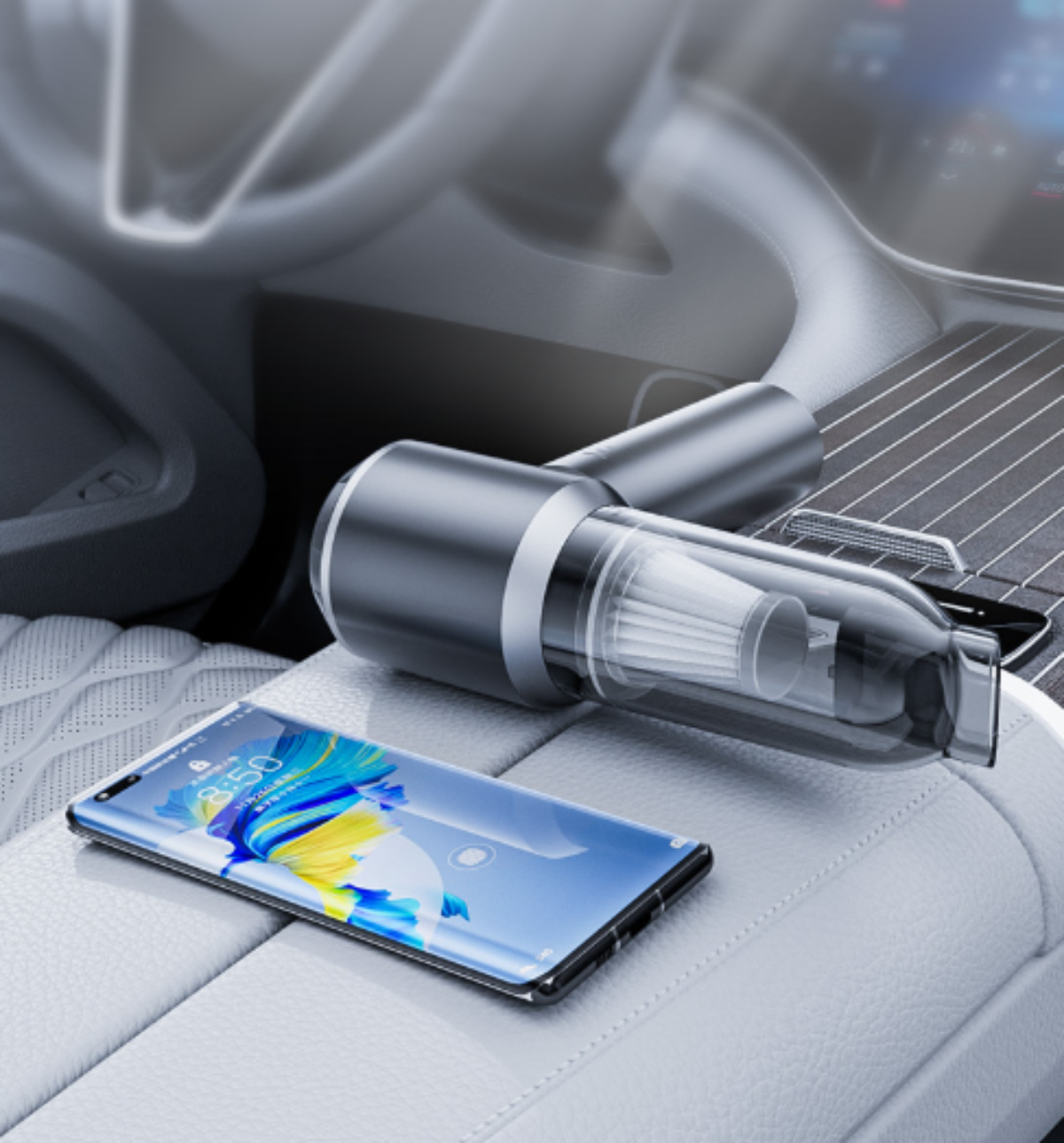 Ein schwarz-silberner Staubsauger in einem Autoinnenraum, der auf einem weißen Ledersitz mit einem Smartphone liegt.