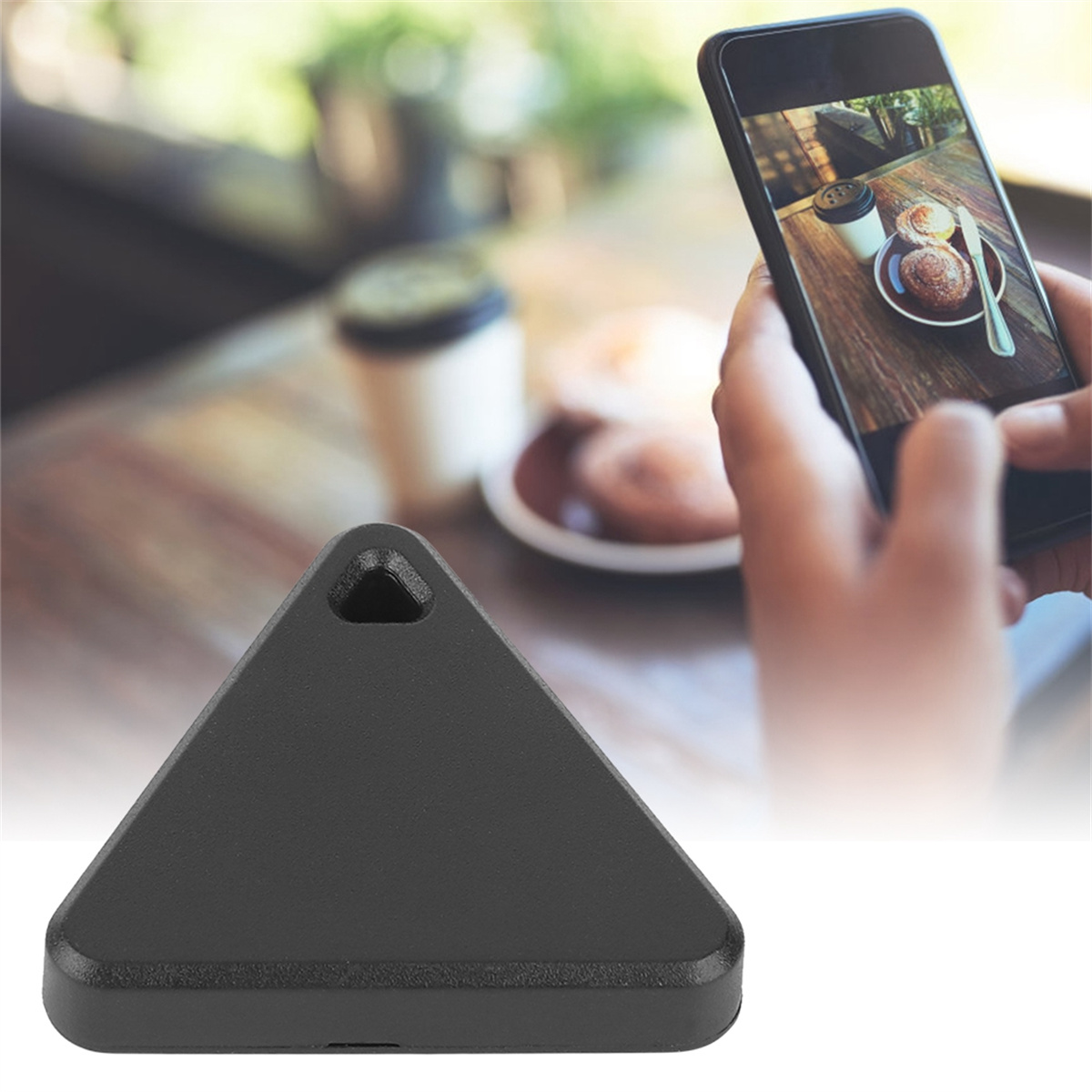 Ein schwarzer dreieckiger Tracker und ein Smartphone, das ein Essensfoto anzeigt, gehalten von einer Person.