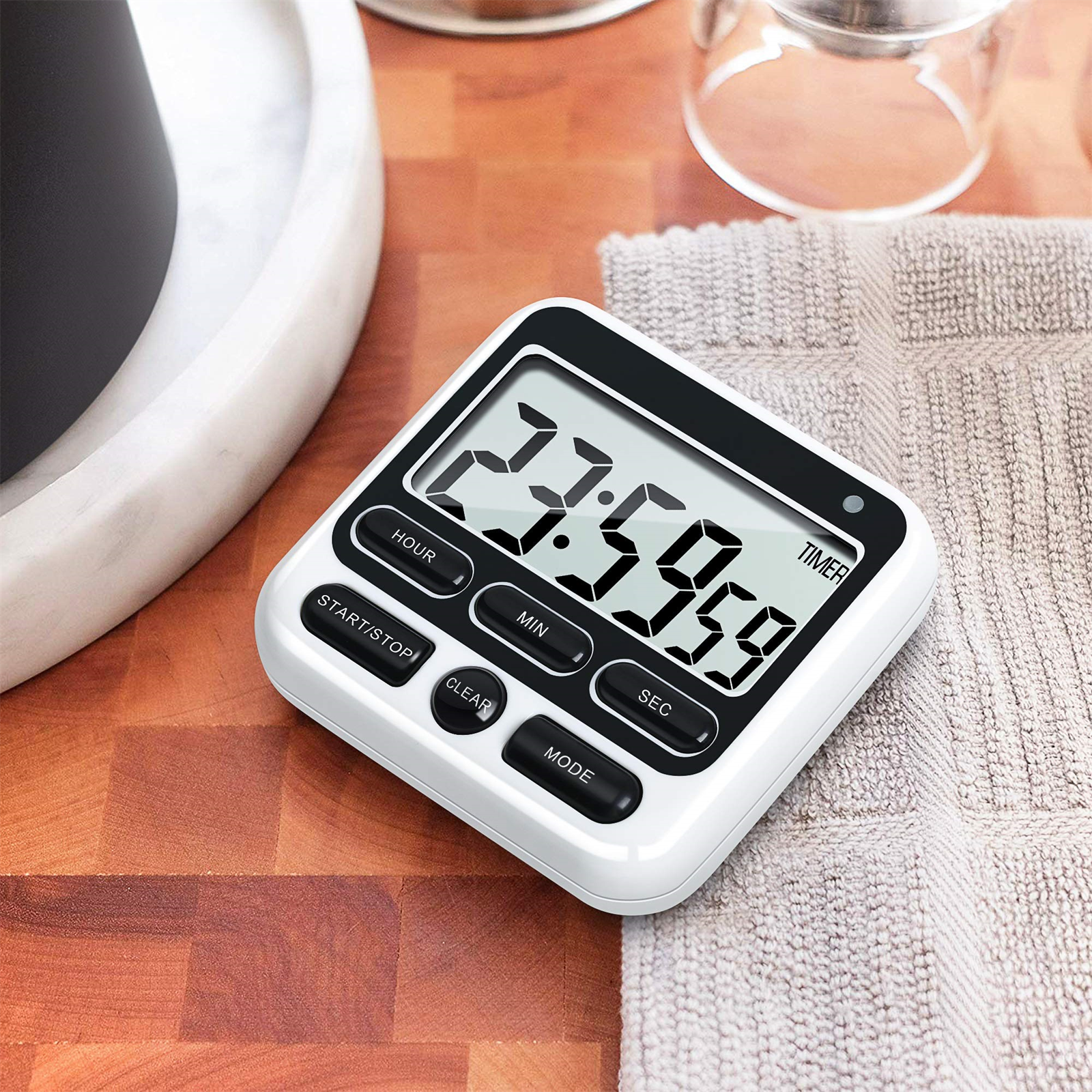 Weißer und schwarzer digitaler Küchentimer auf Holzoberfläche.