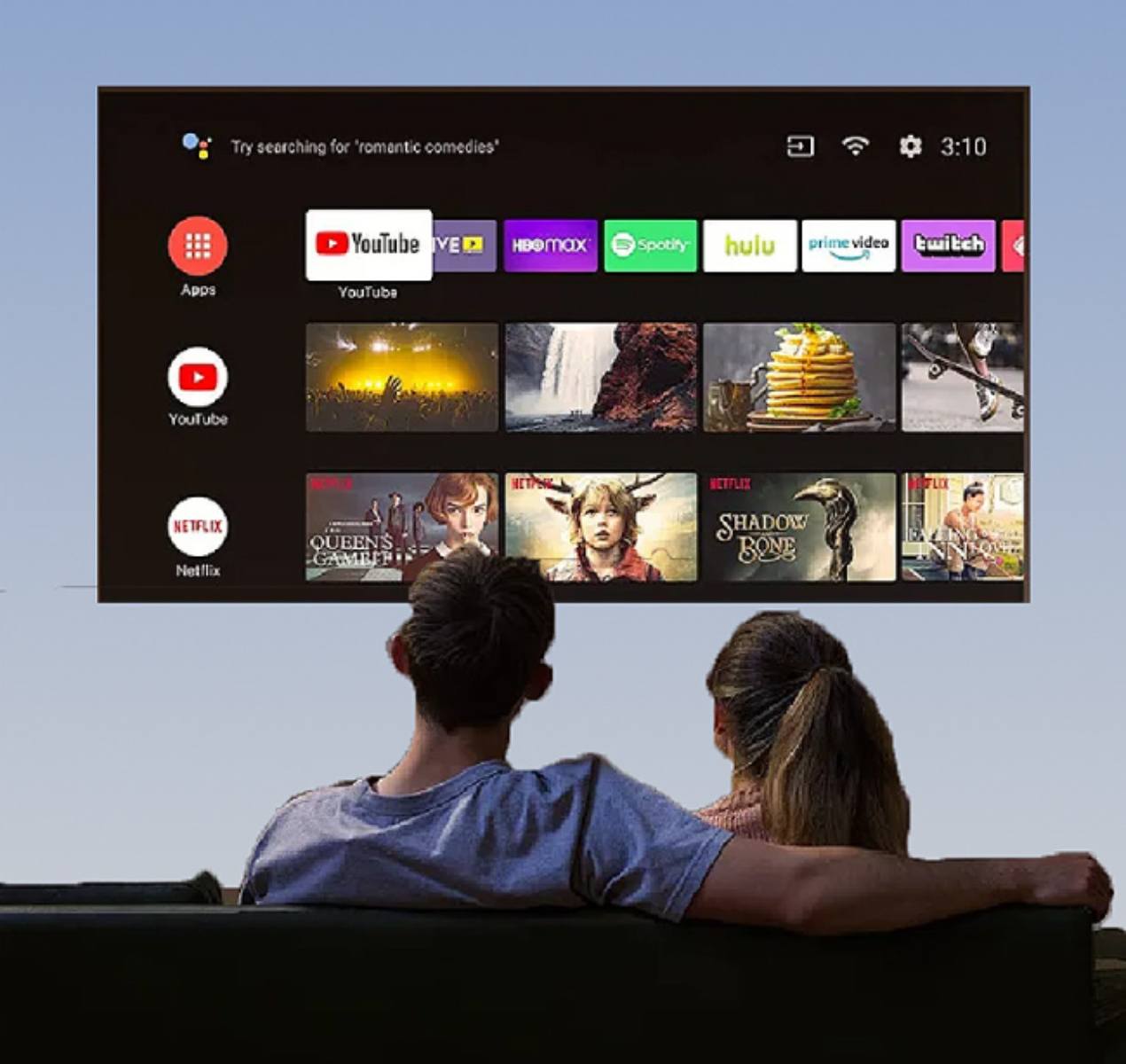 Paar schaut fern, zeigt Apps wie YouTube und Netflix. Eine Suchleiste sagt 'Romantische Komödien'.