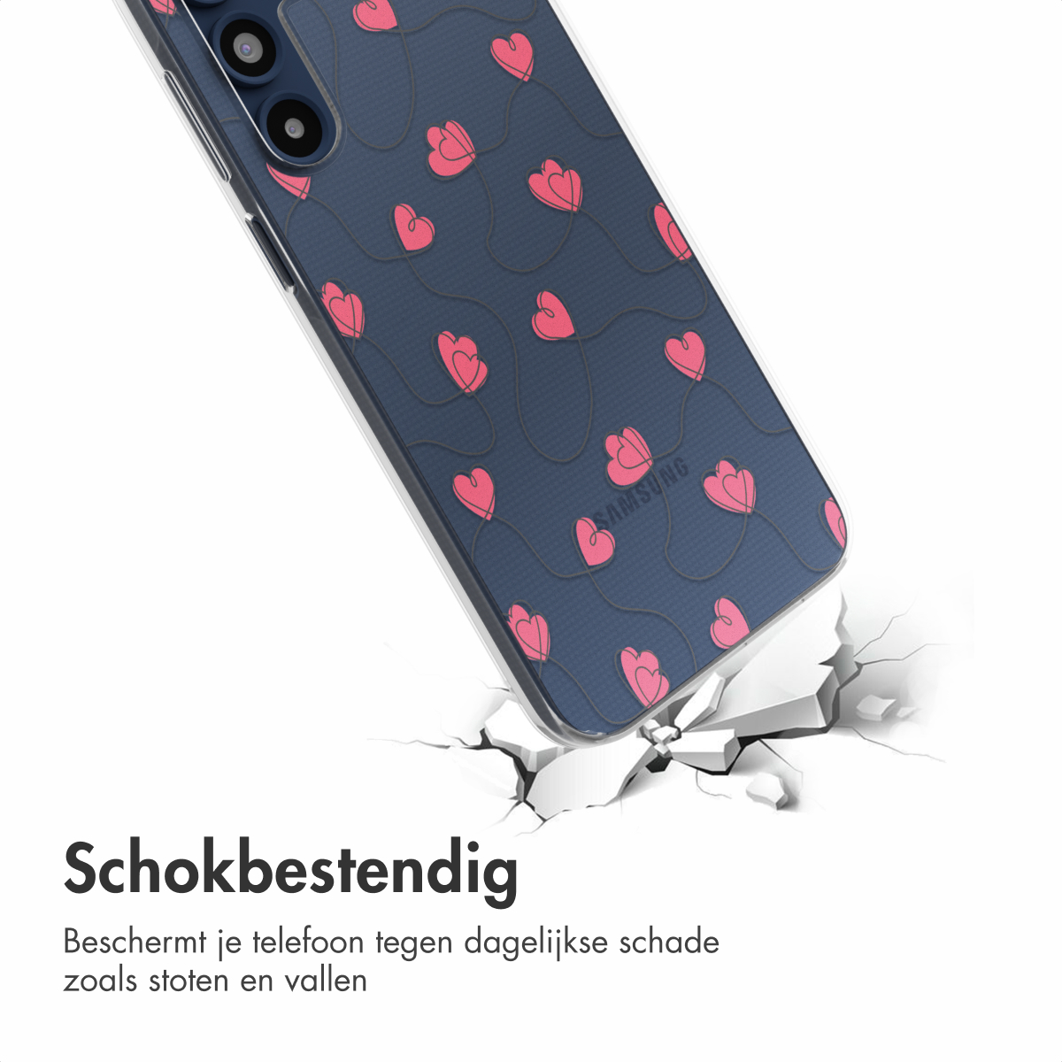 Telefoonhoesje met roze hartjes op een blauwe achtergrond, onder een hoek om de schokbestendigheid te tonen. Gebarsten oppervlak eronder.