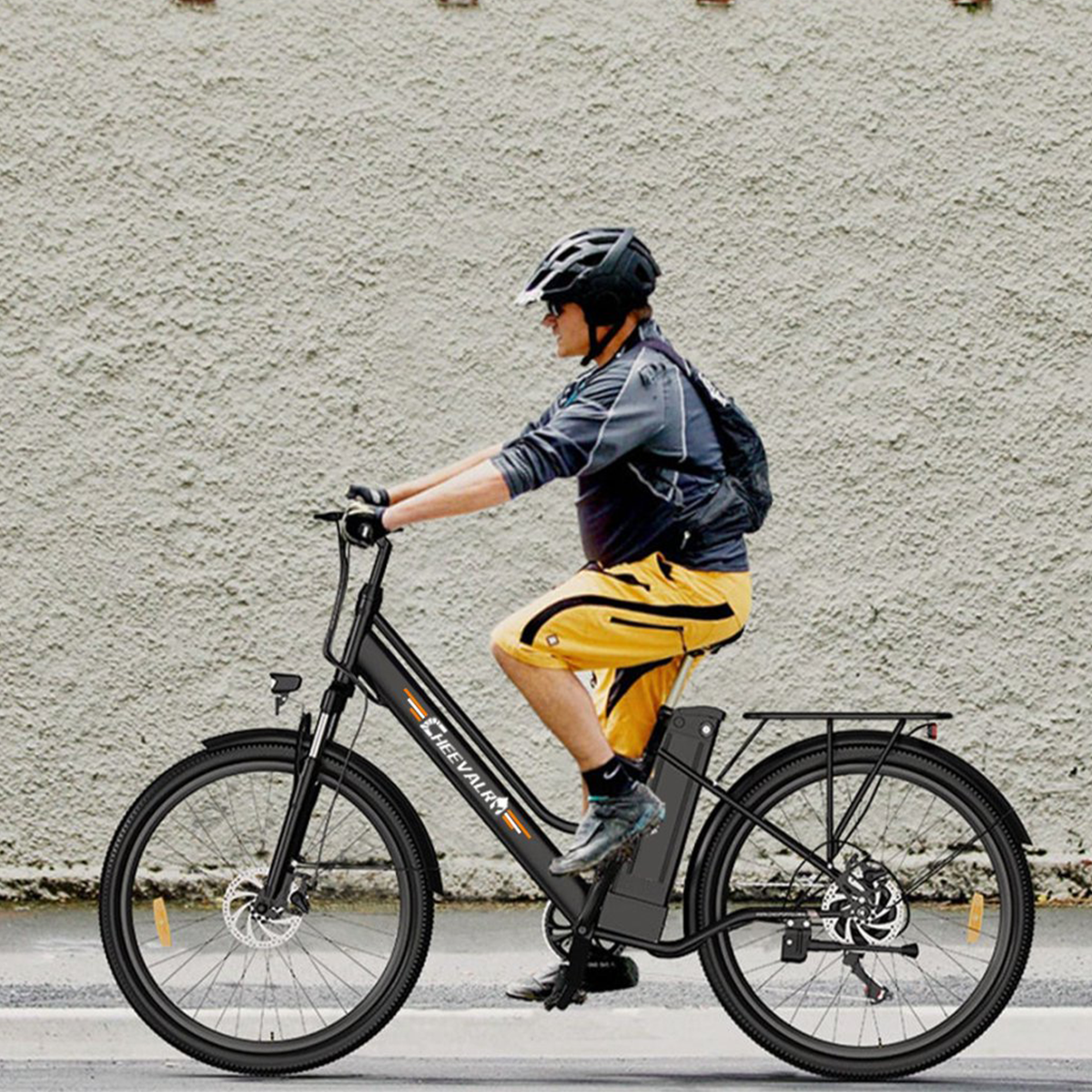 Mężczyzna jadący czarnym rowerem elektrycznym po drodze.