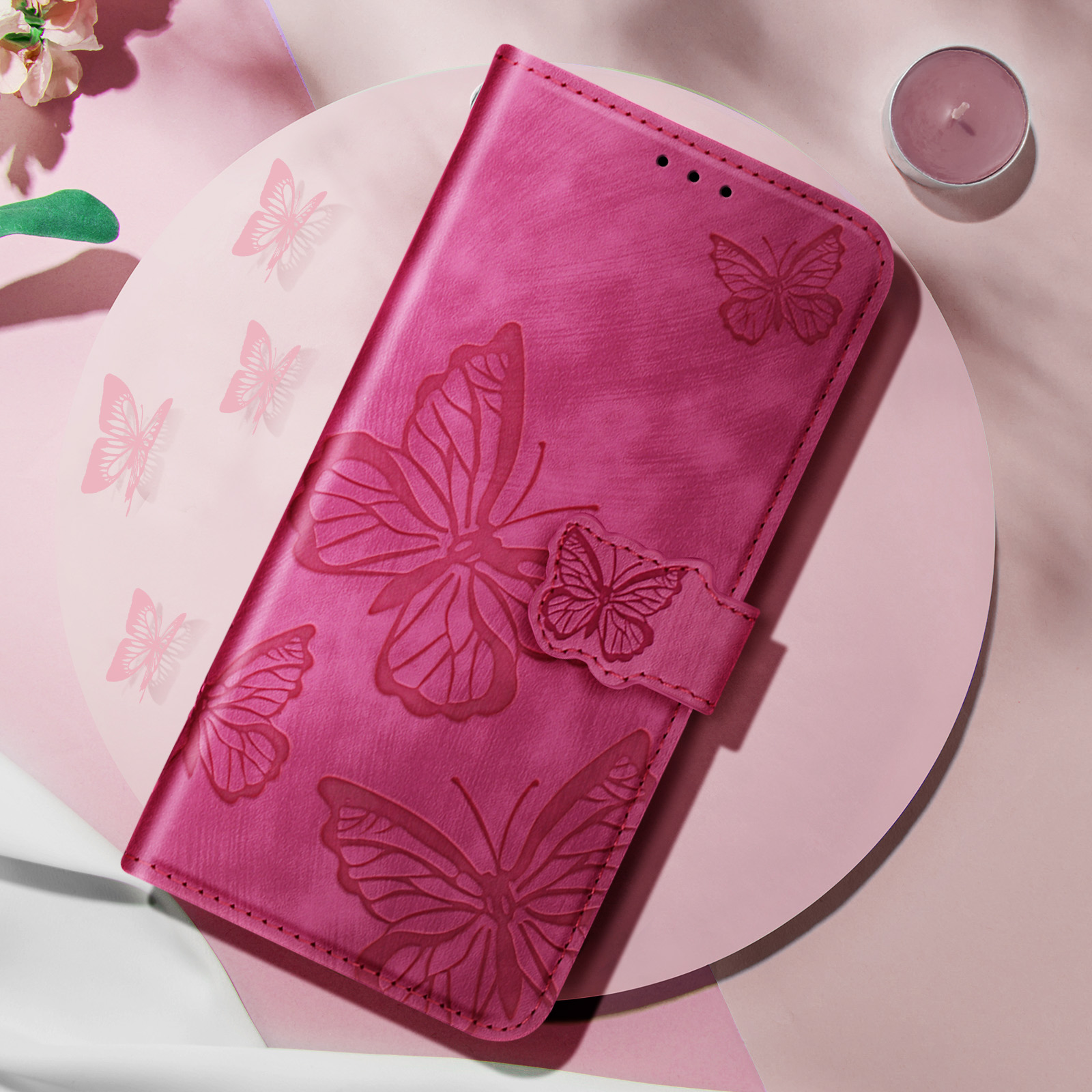 Eine pinke Handyhülle mit Schmetterlingsmuster, geöffnet, zeigt das Innere und das Schmetterlingsdesign.