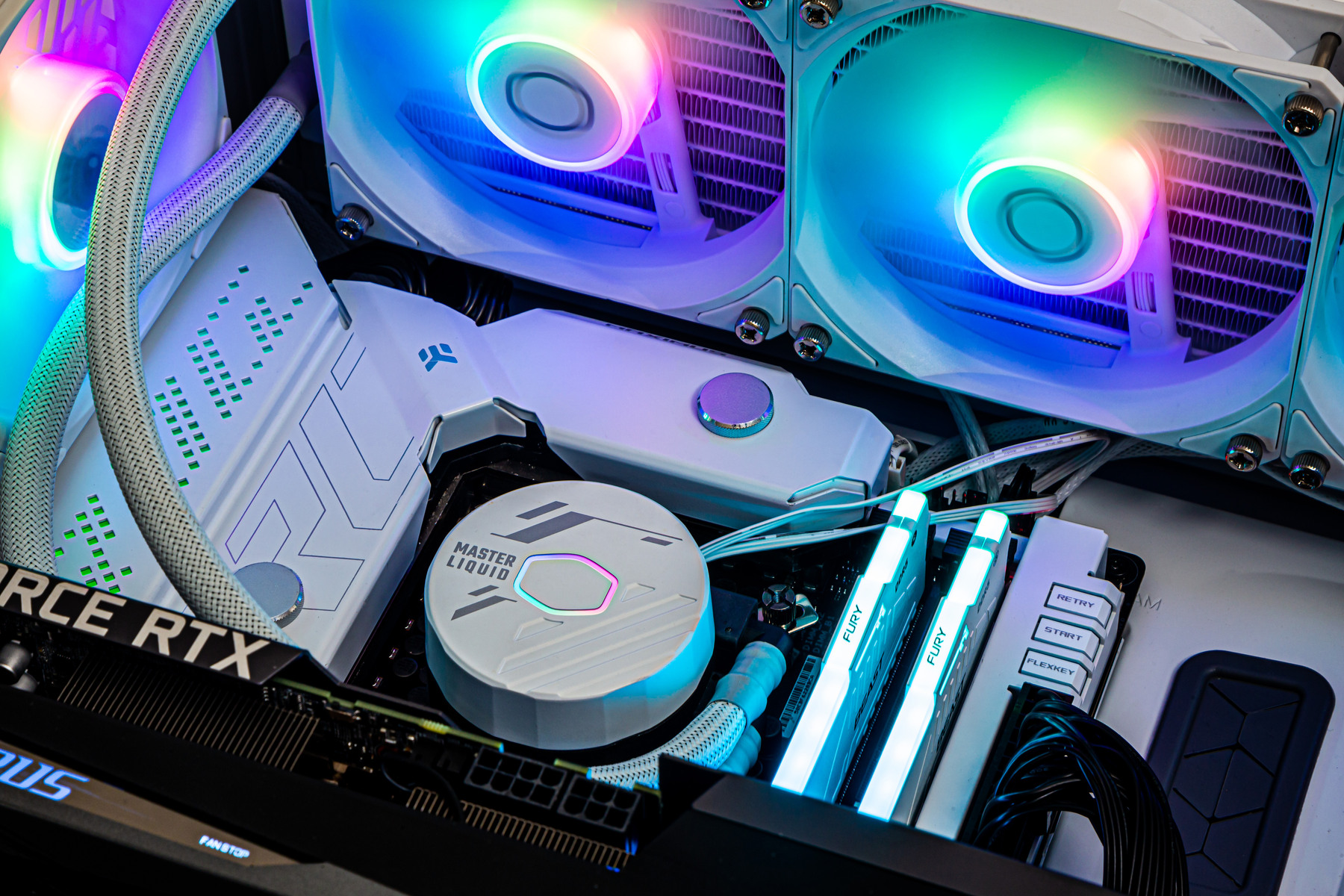 Wnętrze komputera z chłodzeniem cieczą i wentylatorami. Wentylatory świecą światłami RGB.