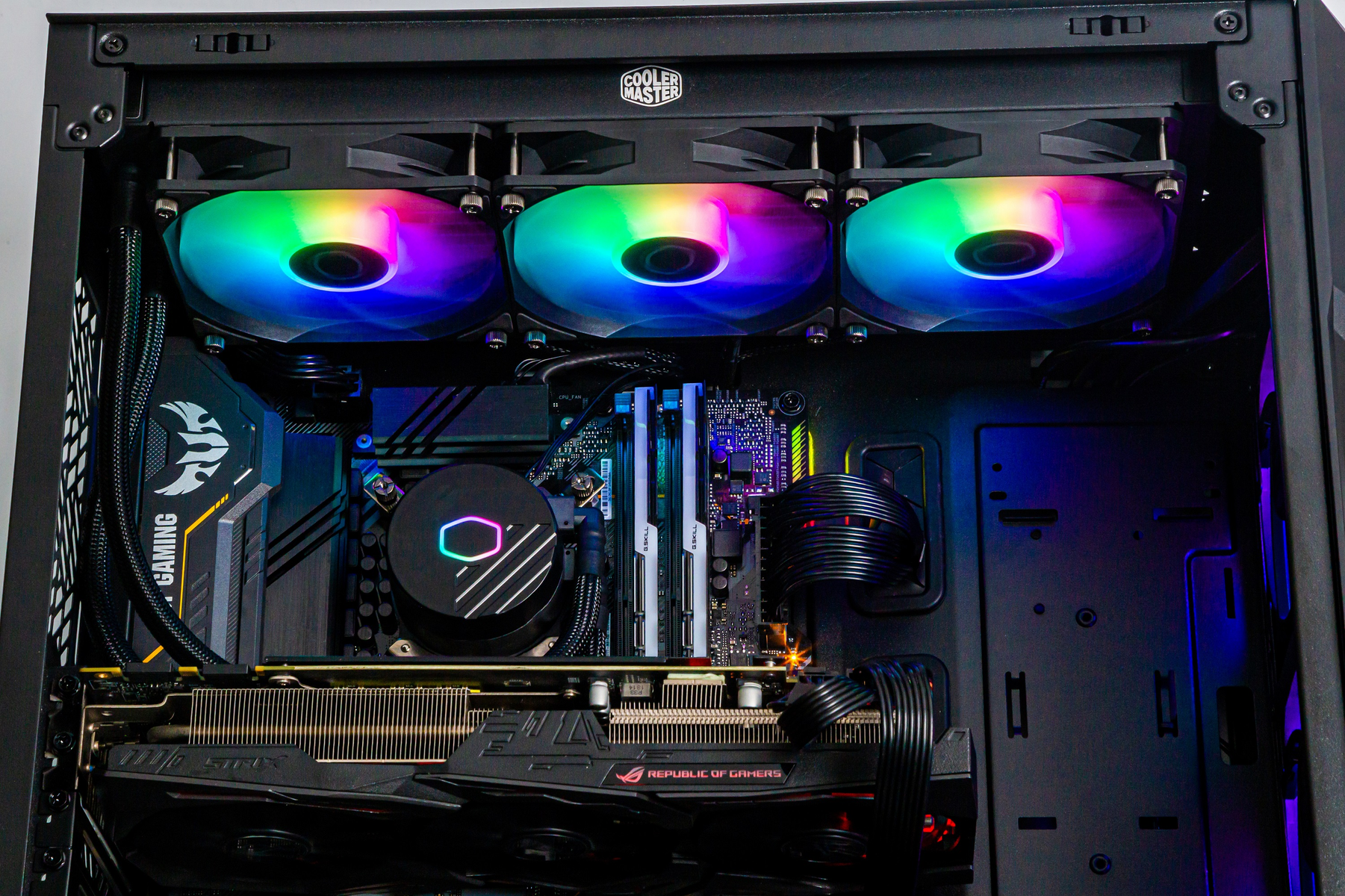 Wnętrze obudowy komputera z wentylatorami, chłodzeniem i podzespołami z kolorowym podświetleniem.
