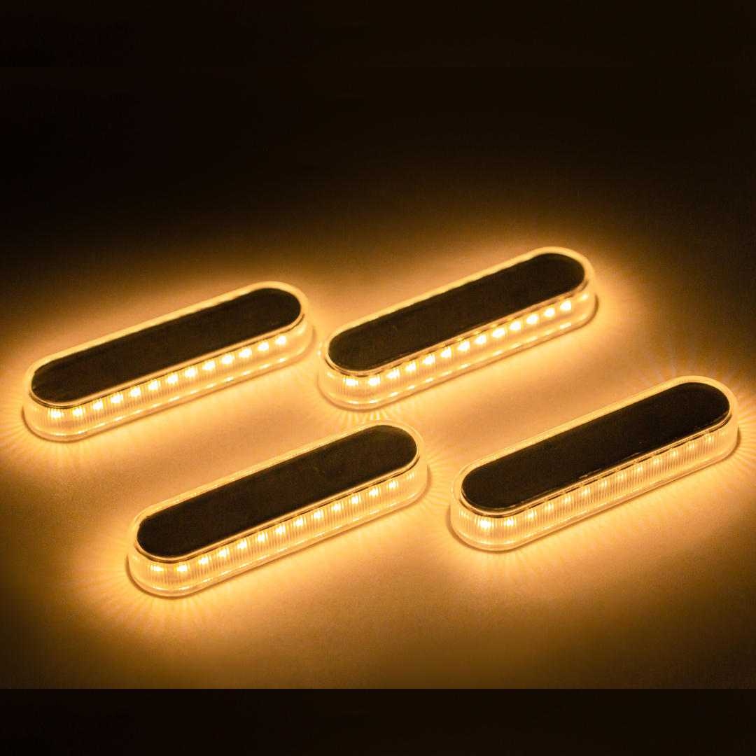 Vier rechteckige LED-Leuchten, horizontal angeordnet, die ein warmes, gelbes Licht aussenden.