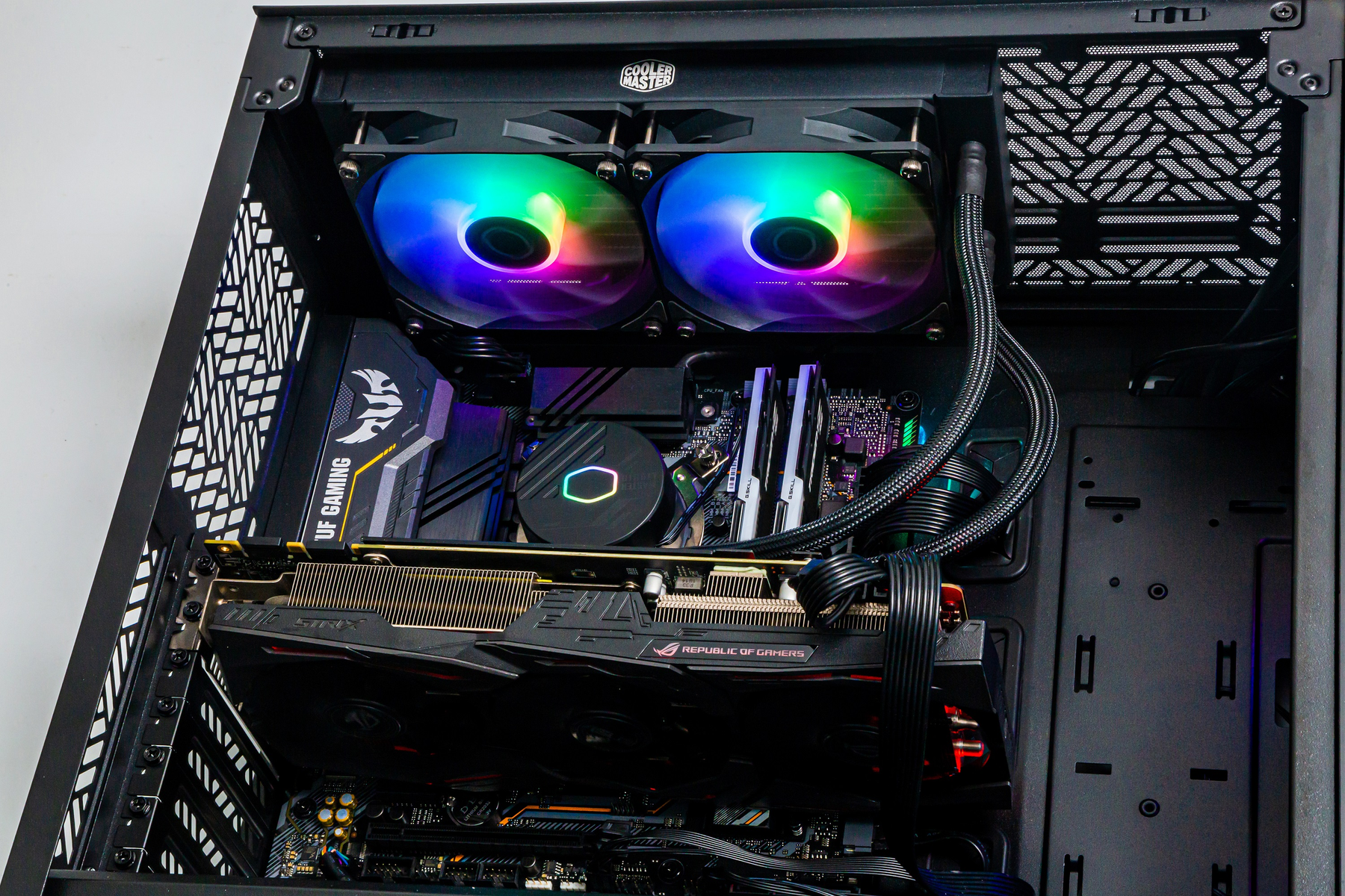 Wewnątrz obudowy komputera, chłodzenie CPU z kolorowymi wentylatorami, GPU i inne komponenty.