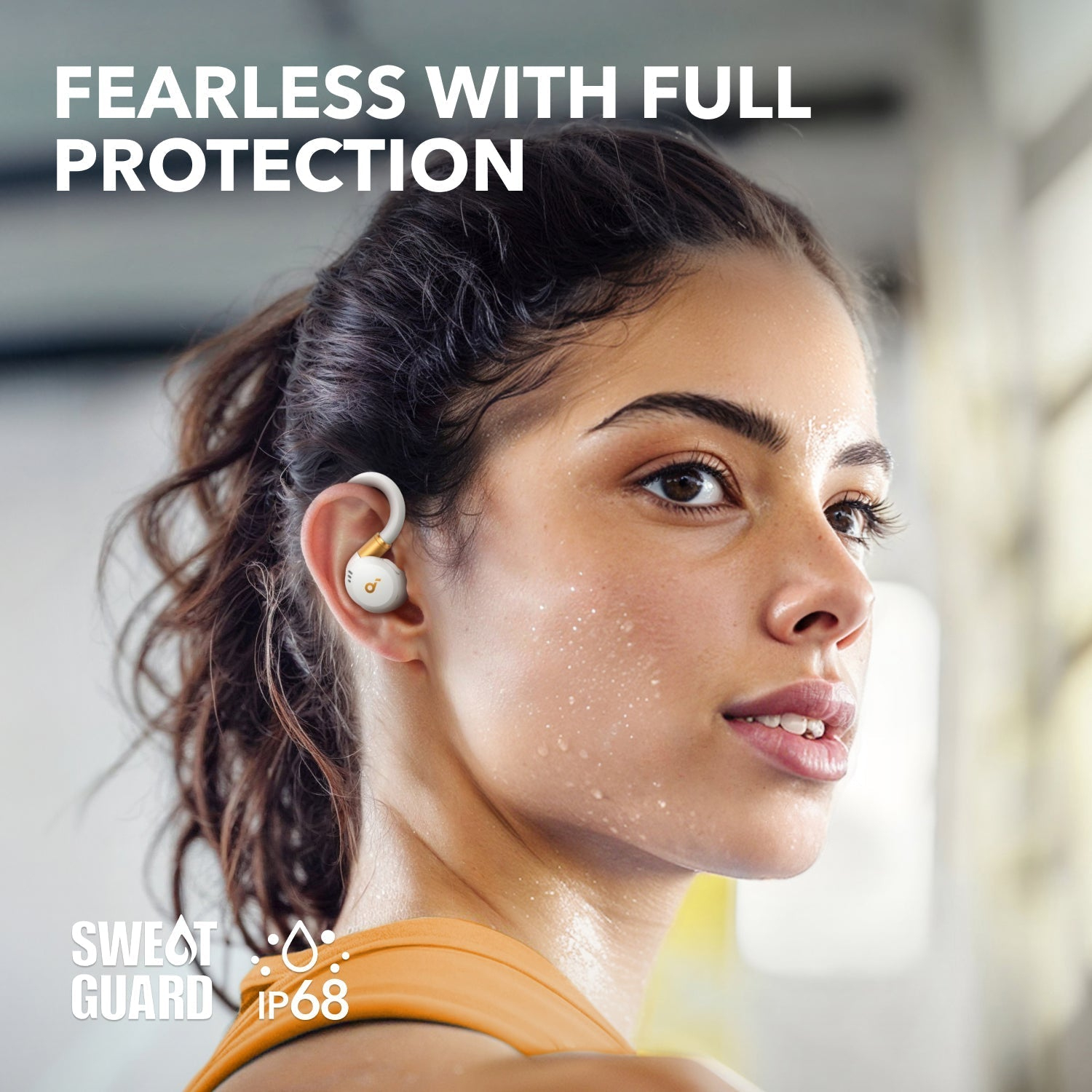 Kobieta w białych i złotych słuchawkach, z potem i tekstem 'FEARLESS WITH FULL PROTECTION'.