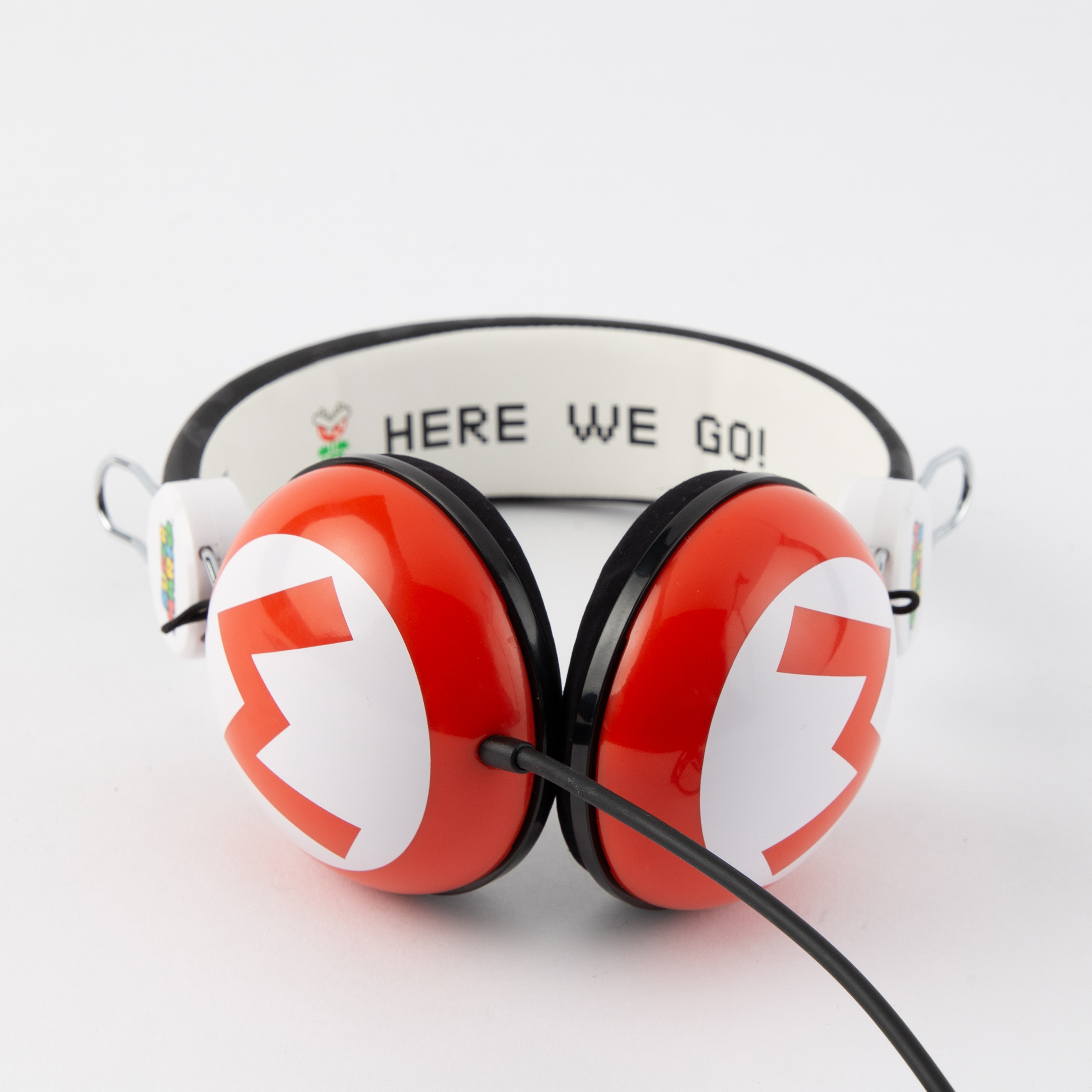 Rote und weiße Kopfhörer im Mario-Design mit schwarzem Kabel. Text auf dem Bügel: 'HERE WE GO!'